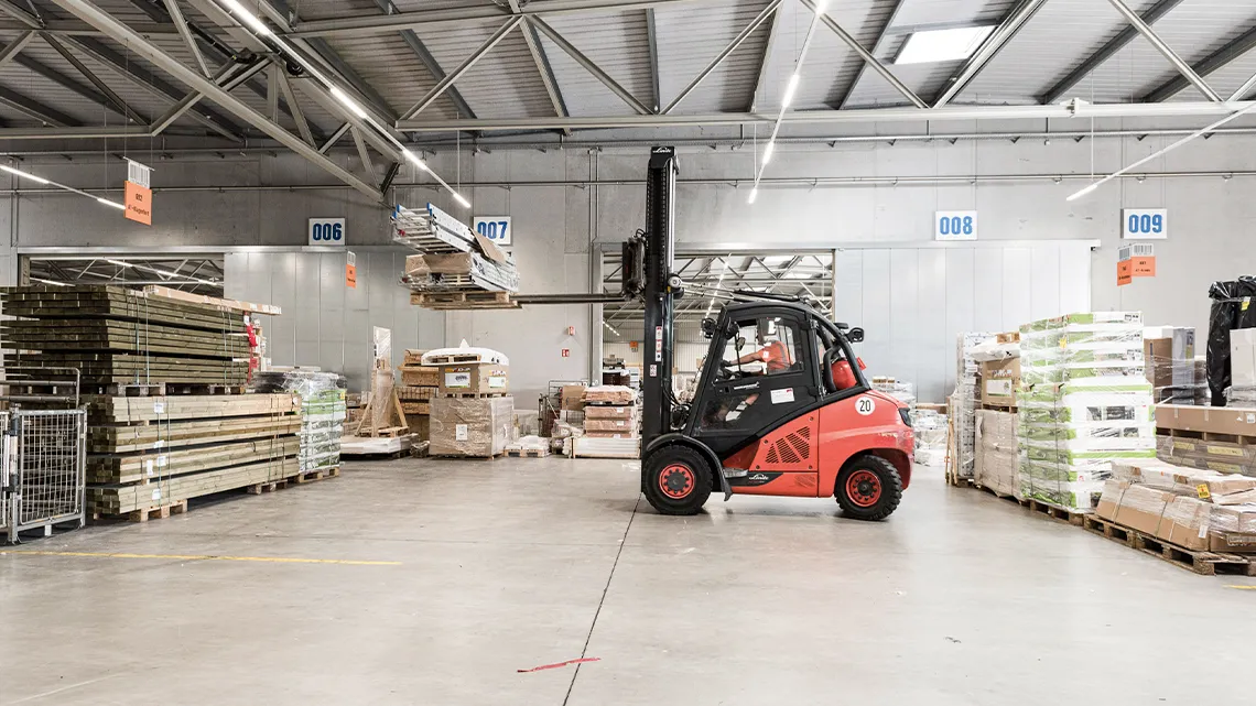 Ein Gabelstapler transportiert Baumaterial in einem Lager von HORNBACH Baumarkt AG.