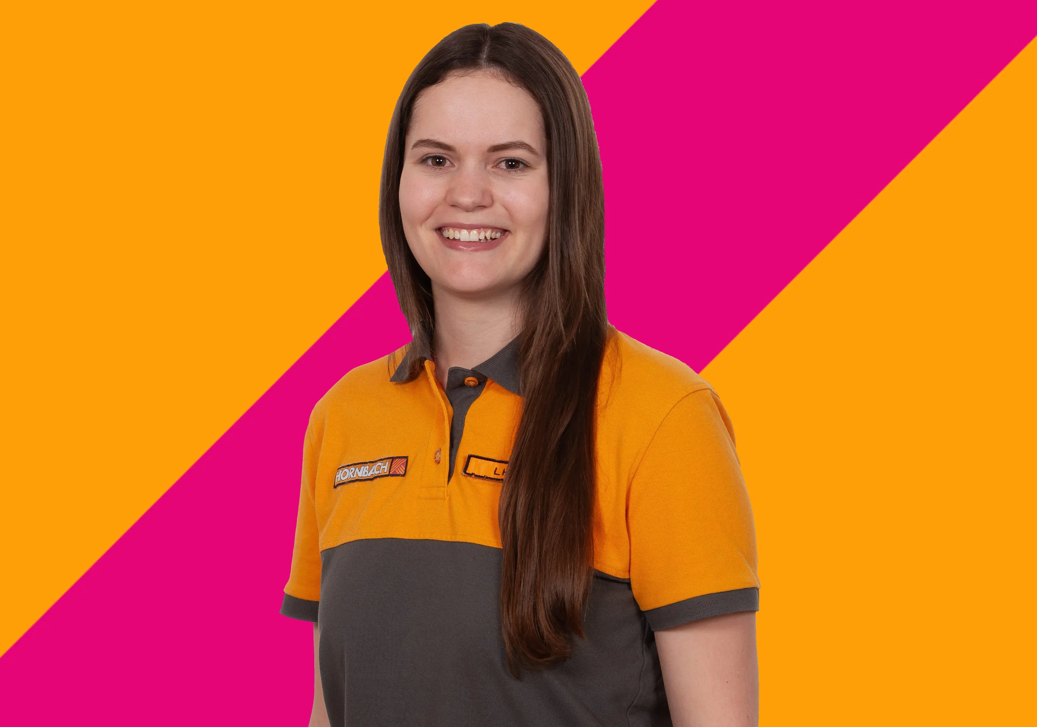 Die lächelnde Mitarbeiterin Lena Haas von HORNBACH in orange-grauer Uniform vor einem bunten Hintergrund.