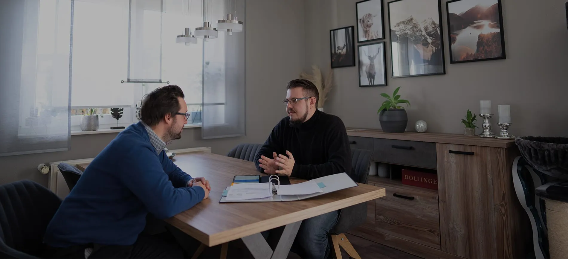 Zwei Kollegen führen ein Beratungsgespräch am Tisch in einem modernen, gemütlichen Büro bei impeak GmbH.