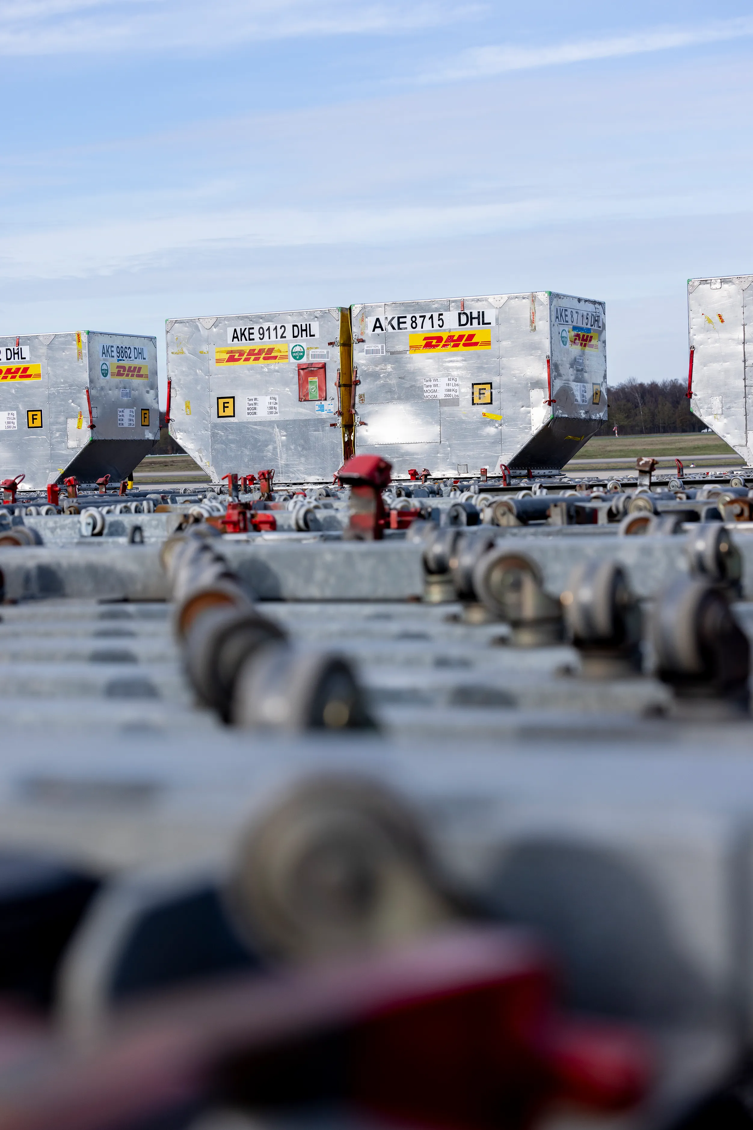 Container auf einem Rollbahnensystem am Flughafen, bereit für den Transport.