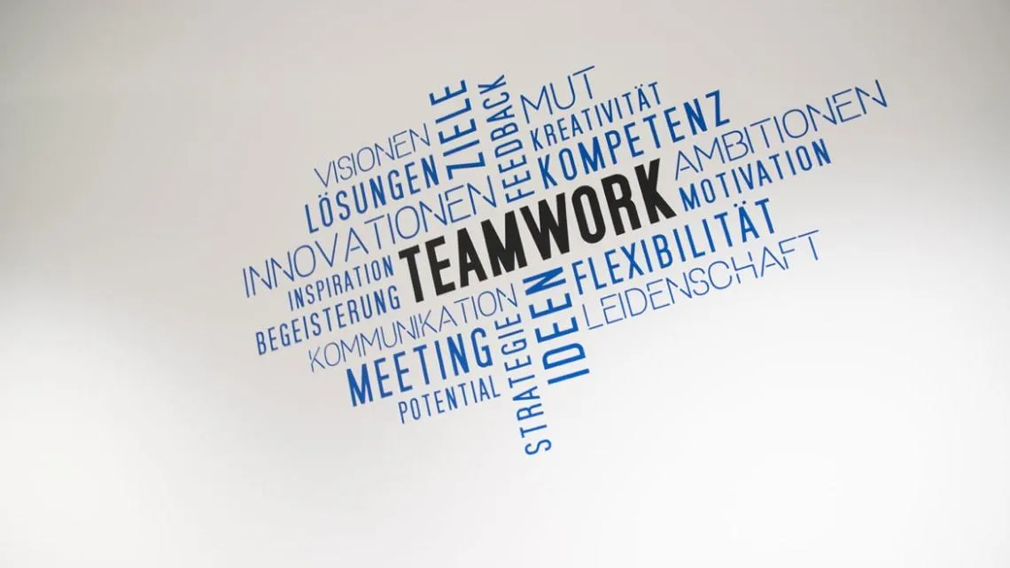 Wand mit inspirierenden Begriffen wie „Teamwork“, „Kompetenz“ und „Flexibilität“ für Deine Karriere bei KVM ServicePlus.