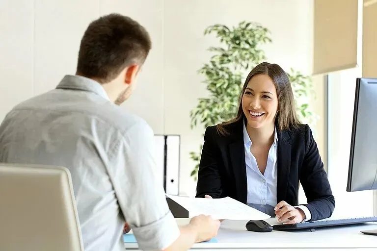 Eine Recruiterin von Leadec führt ein freundliches Bewerbungsgespräch mit einem Bewerber im modernen Büro.