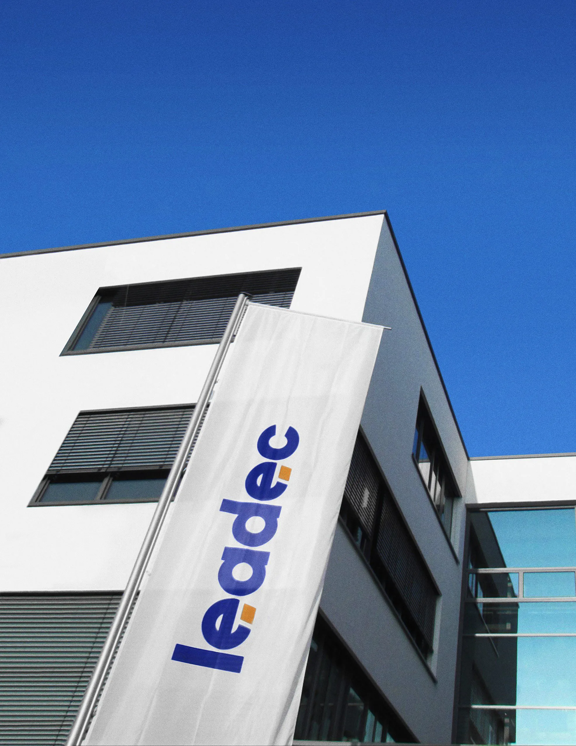 Modernes Bürogebäude von Leadec mit Firmenlogo und blauem Himmel – Dein möglicher neuer Arbeitsplatz.