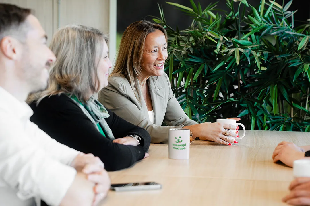 Deux collègues discutant devant un tableau blanc rempli d'idées et de croquis dans un bureau chez Maxi Zoo France.