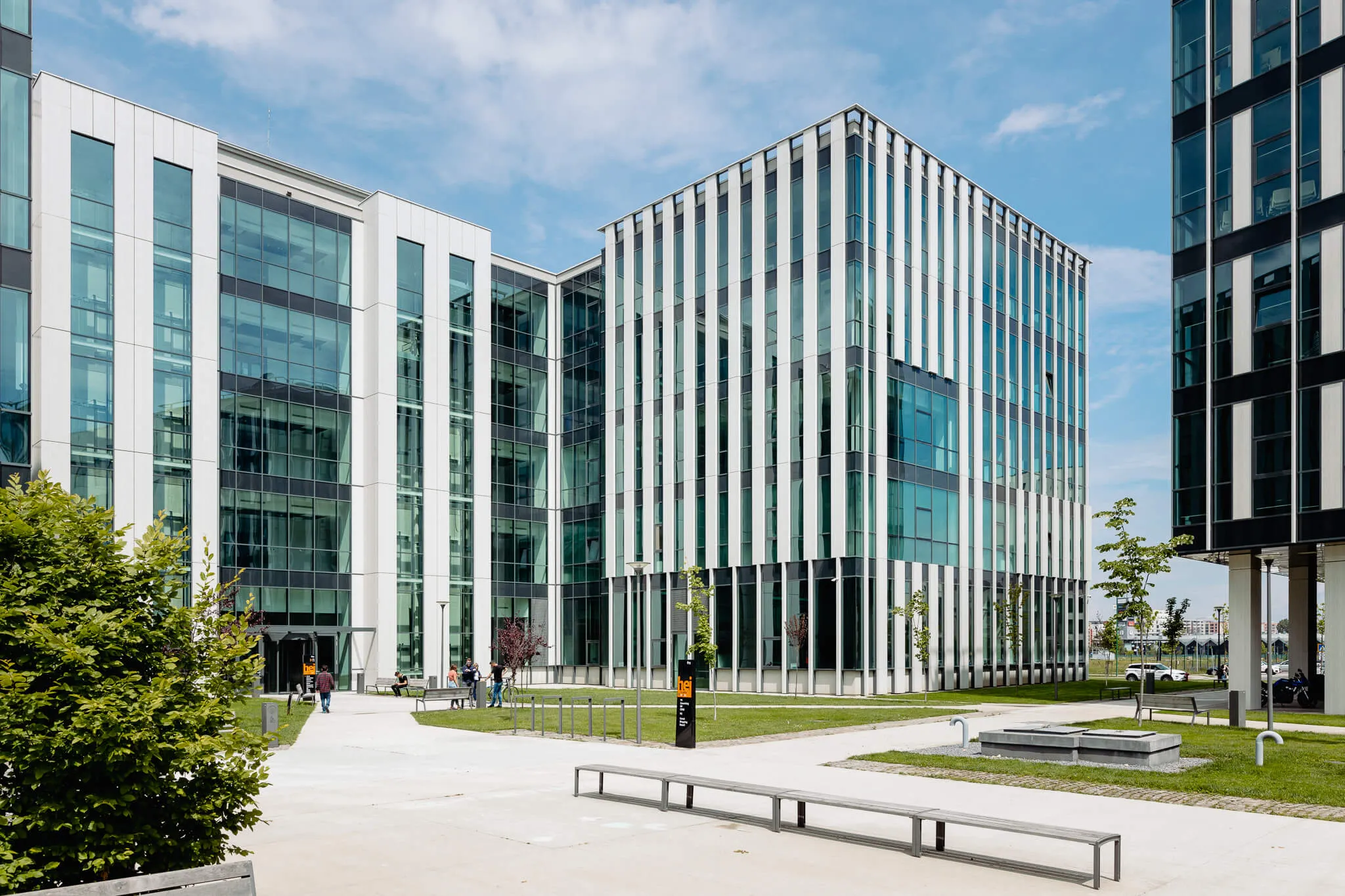 Clădire modernă a Miele & Cie. KG, cu fațadă din sticlă, pe un fundal de cer senin, într-un campus verde.