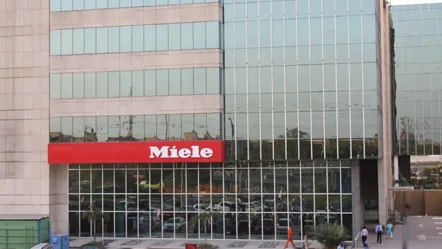 Das Gebäude von Miele in Indien mit Glasfassade und rotem Miele-Logo.