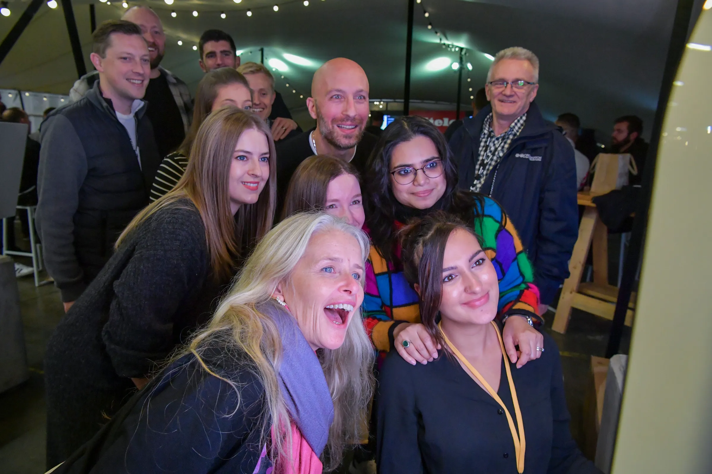 A family stands outside a modern home surrounded by greenery, highlighting Miele's commitment to sustainability.