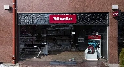 Miele store entrance in Bulgaria showcasing a sleek vacuum display, inviting you into the world of quality manufacturing.