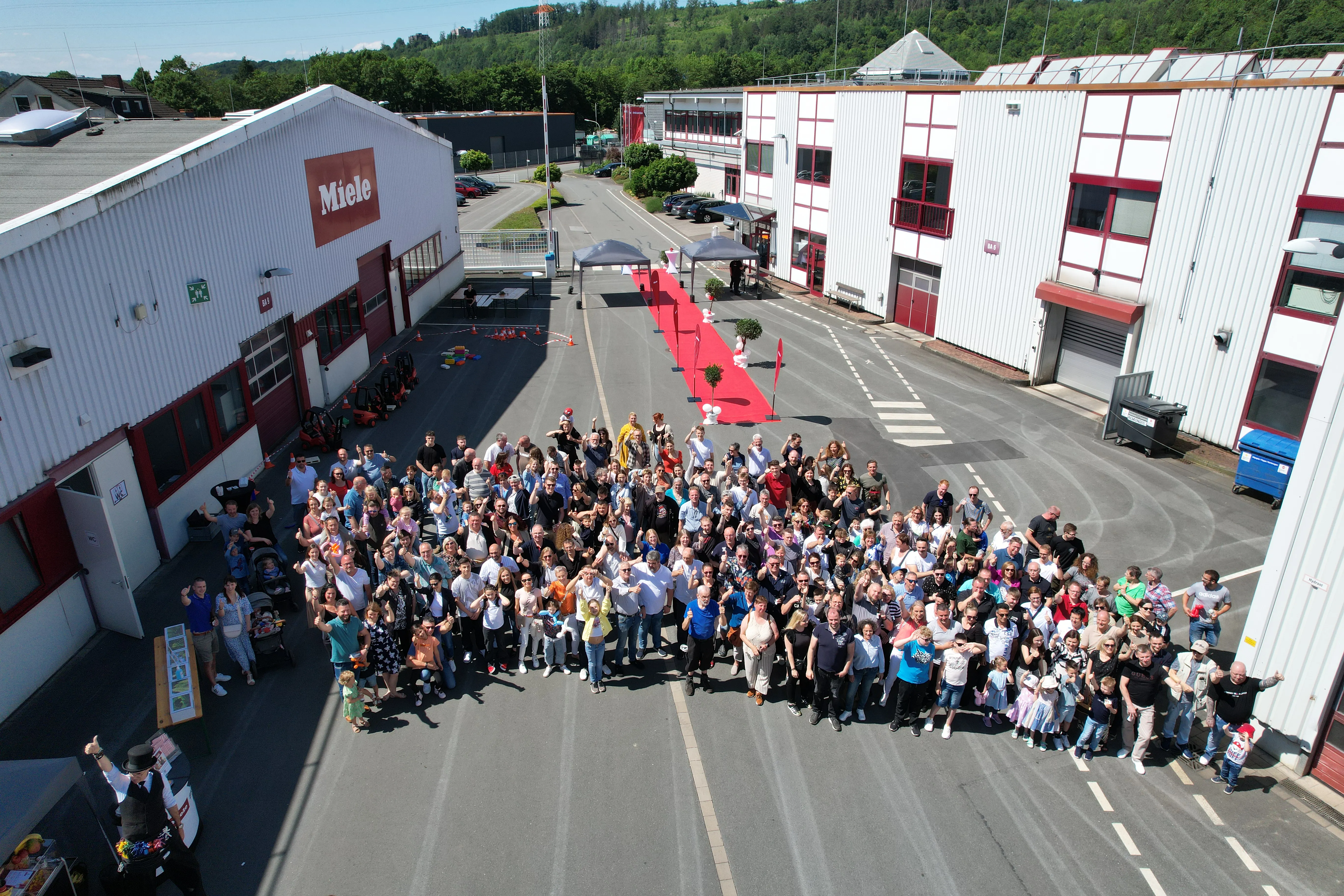 Große Gruppe von Menschen versammelt vor einem Miele-Gebäude bei einer Firmenveranstaltung in Arnsberg..