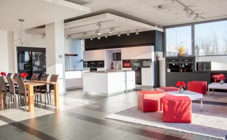 Modern Miele showroom in Sloveniawith sleek kitchen setup, dining area, and cozy seating. Perfect spot to imagine your dream kitchen!