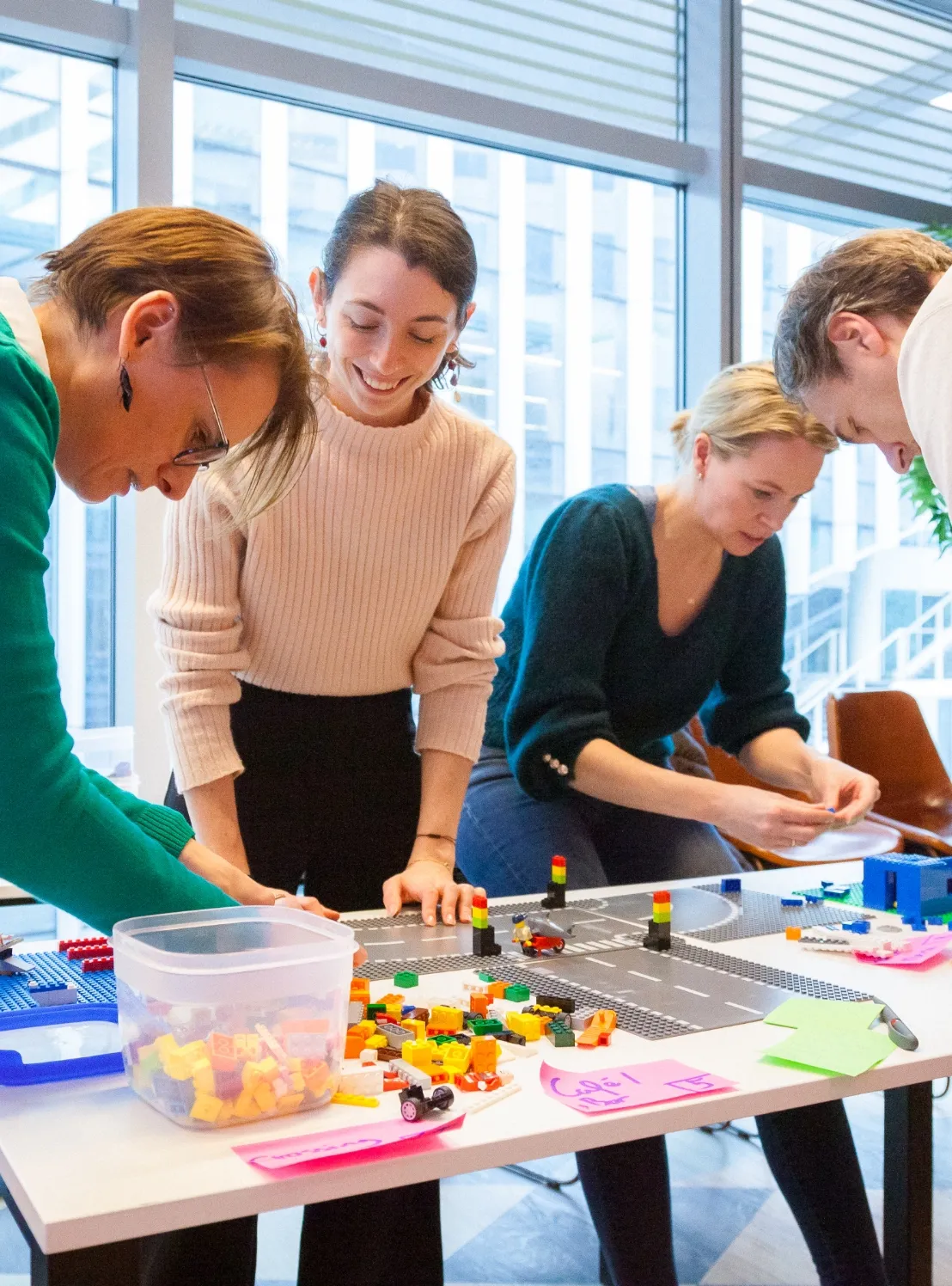 A group of colleagues at Miele having fun building creative projects with LEGO bricks during a team workshop.