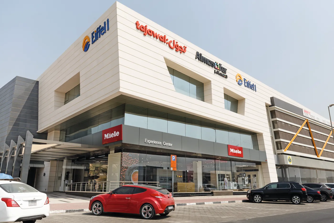 Miele Experience Center in Dubai einem modernen Gebäude mit einem roten Auto im Vordergrund.