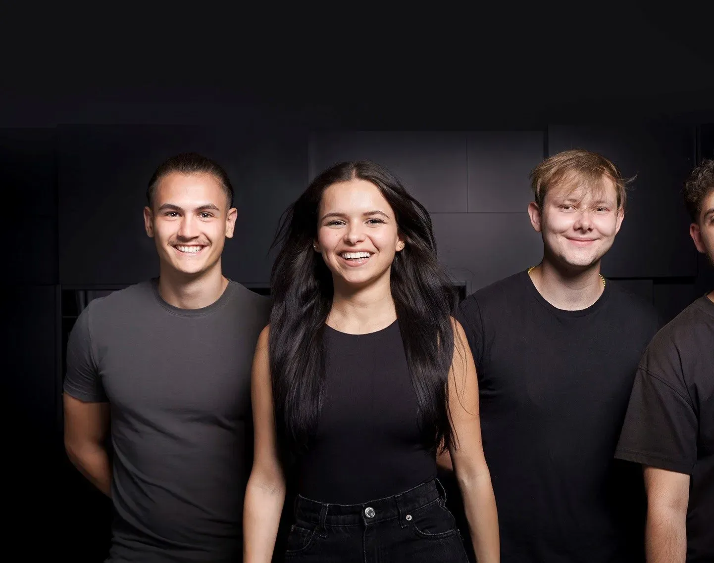 Eine Gruppe junger Menschen lächelt in die Kamera, symbolisiert Teamgeist bei Miele im Bereich Fertigung.