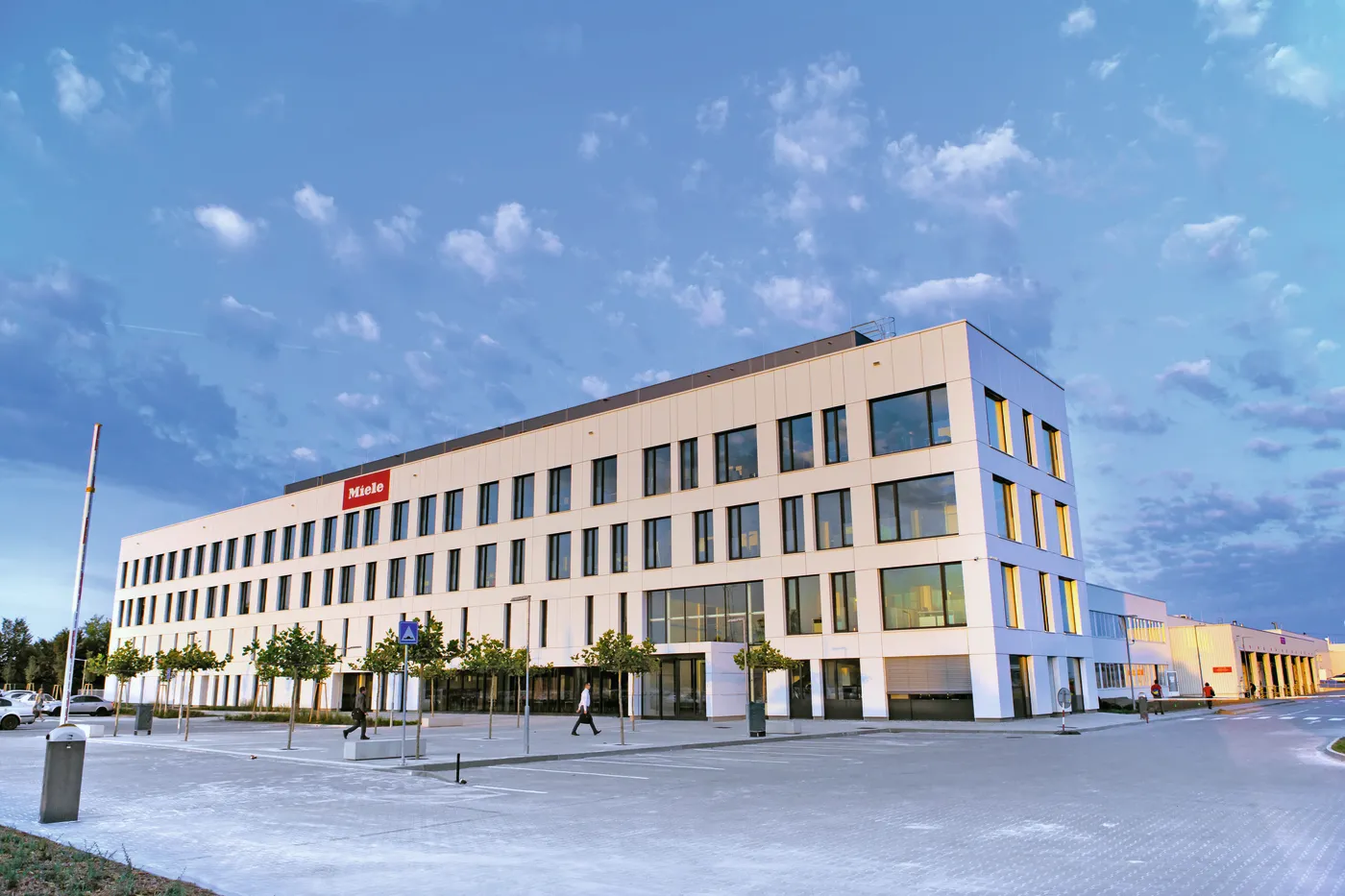 Moderní budova společnosti Miele za jasného dne, ideální místo pro práci v oboru výroby.