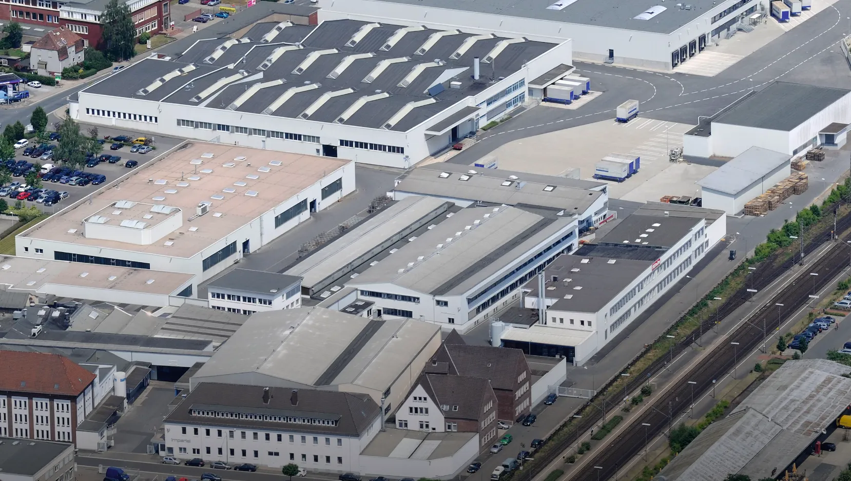 Industriestandort von Miele & Cie. KG aus der Vogelperspektive mit Fabrikgebäuden und Parkplätzen.