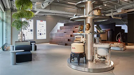 A modern Miele office in Sweden featuring vintage appliances and sleek seating, perfect for exploring innovation in manufacturing.