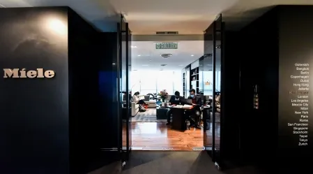 Eine moderne Büroumgebung bei Miele & Cie. KG in Malaysia mit Mitarbeitern, die an einem Besprechungstisch arbeiten.