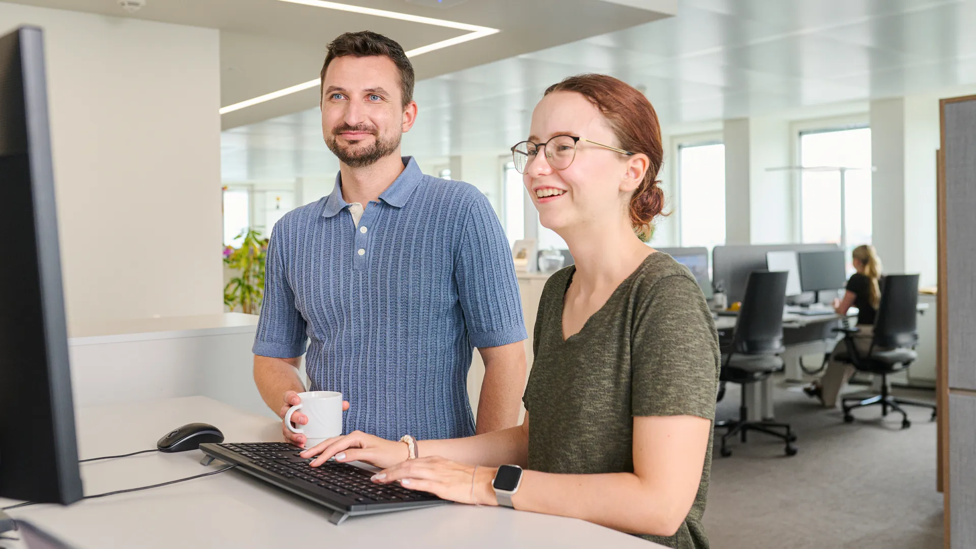 Eine Frau präsentiert einem Kollegen die Online-Services von N-ERGIE Netz GmbH auf einem Bildschirm.