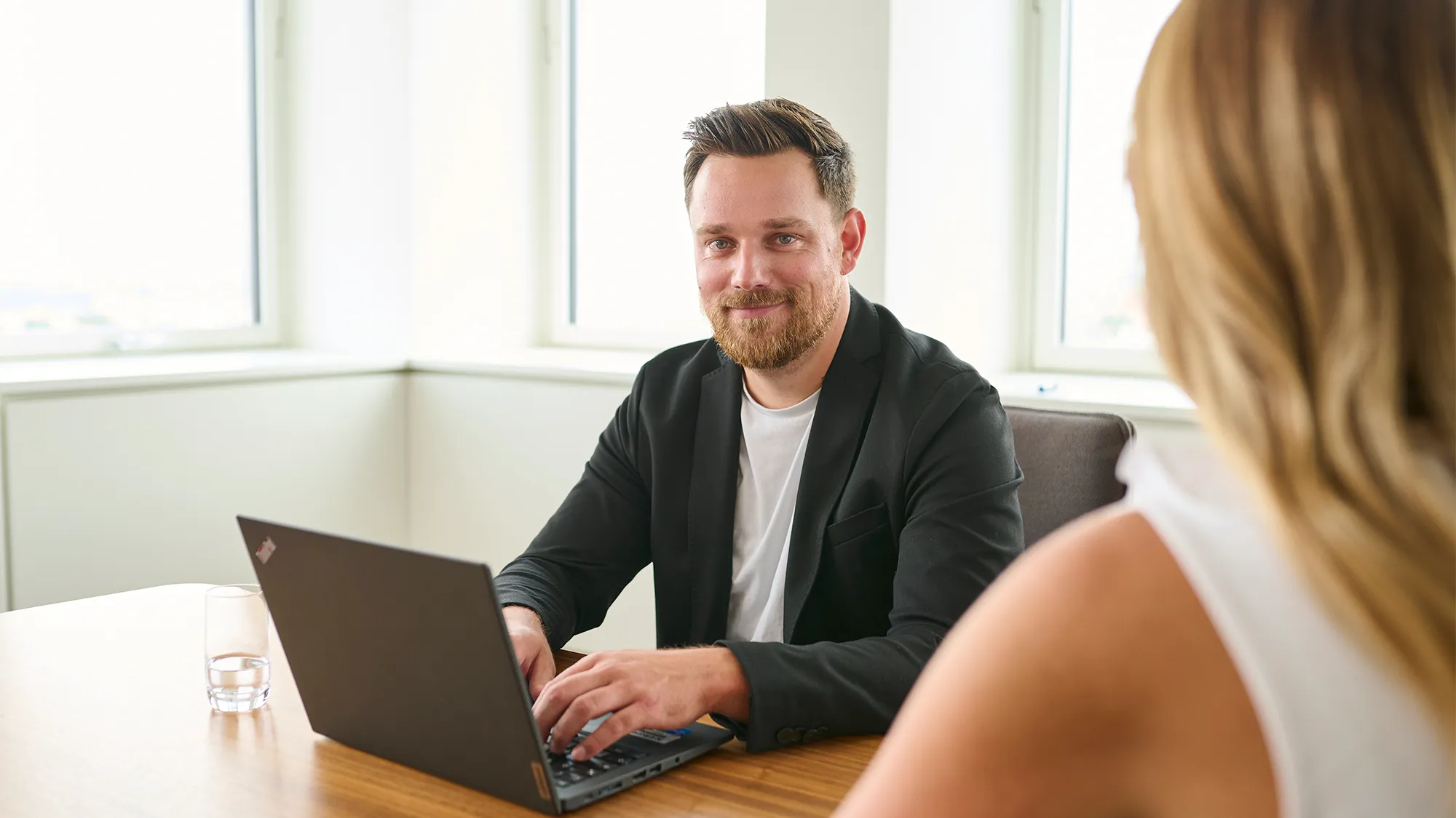 Ein Mitarbeiter führt ein Gespräch am Laptop in einem modernen Büro bei N-ERGIE, Energiebranche.