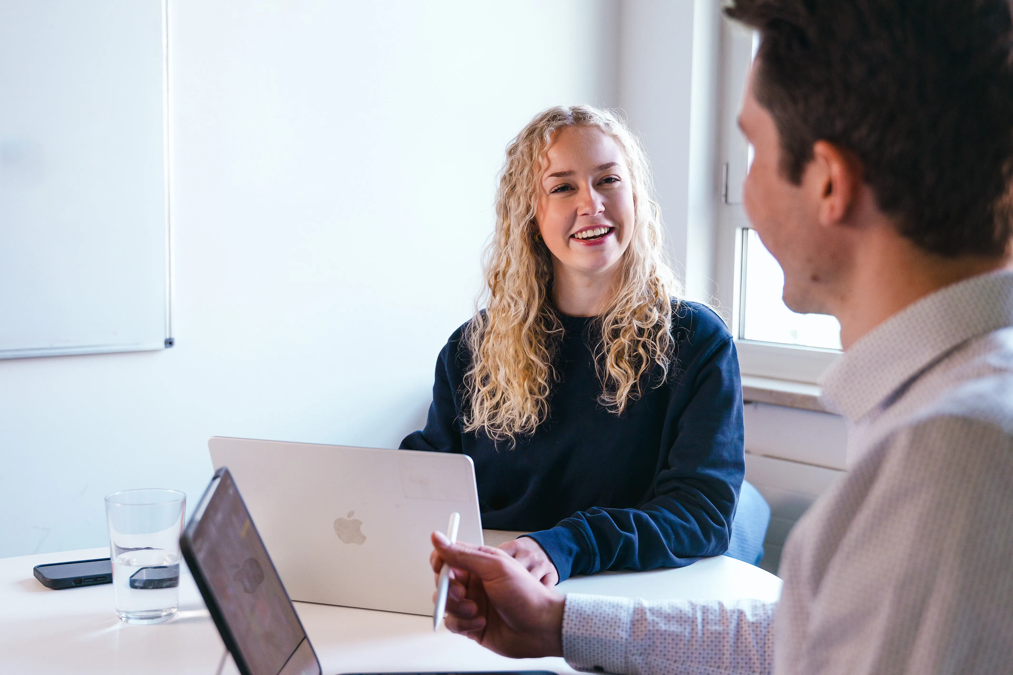 Zwei junge Kollegen im Gespräch im Büro, du arbeitest gemeinsam mit motivierten Teams bei OBI im Einzelhandel.