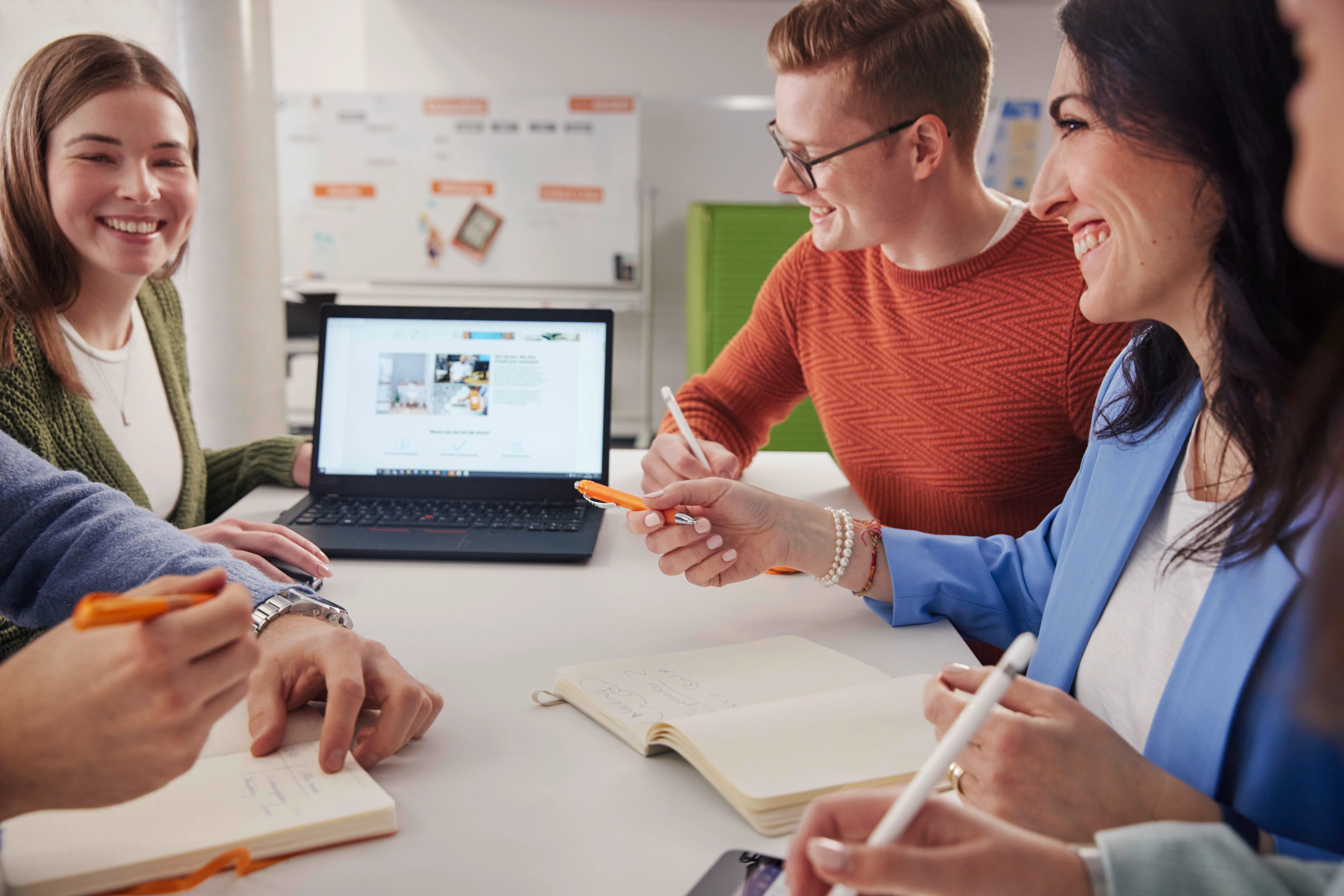 Drei Mitarbeiter:innen stehen gemeinsam im OBI Büro