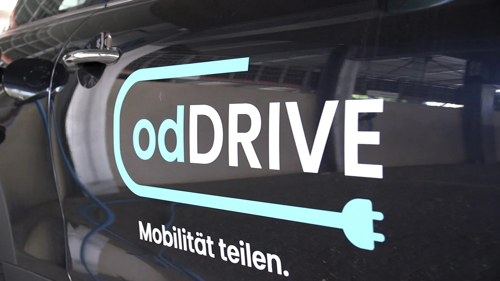 Autotür mit dem Schriftzug 'odDRIVE' und Slogan 'Mobilität teilen' von opta data Gruppe.