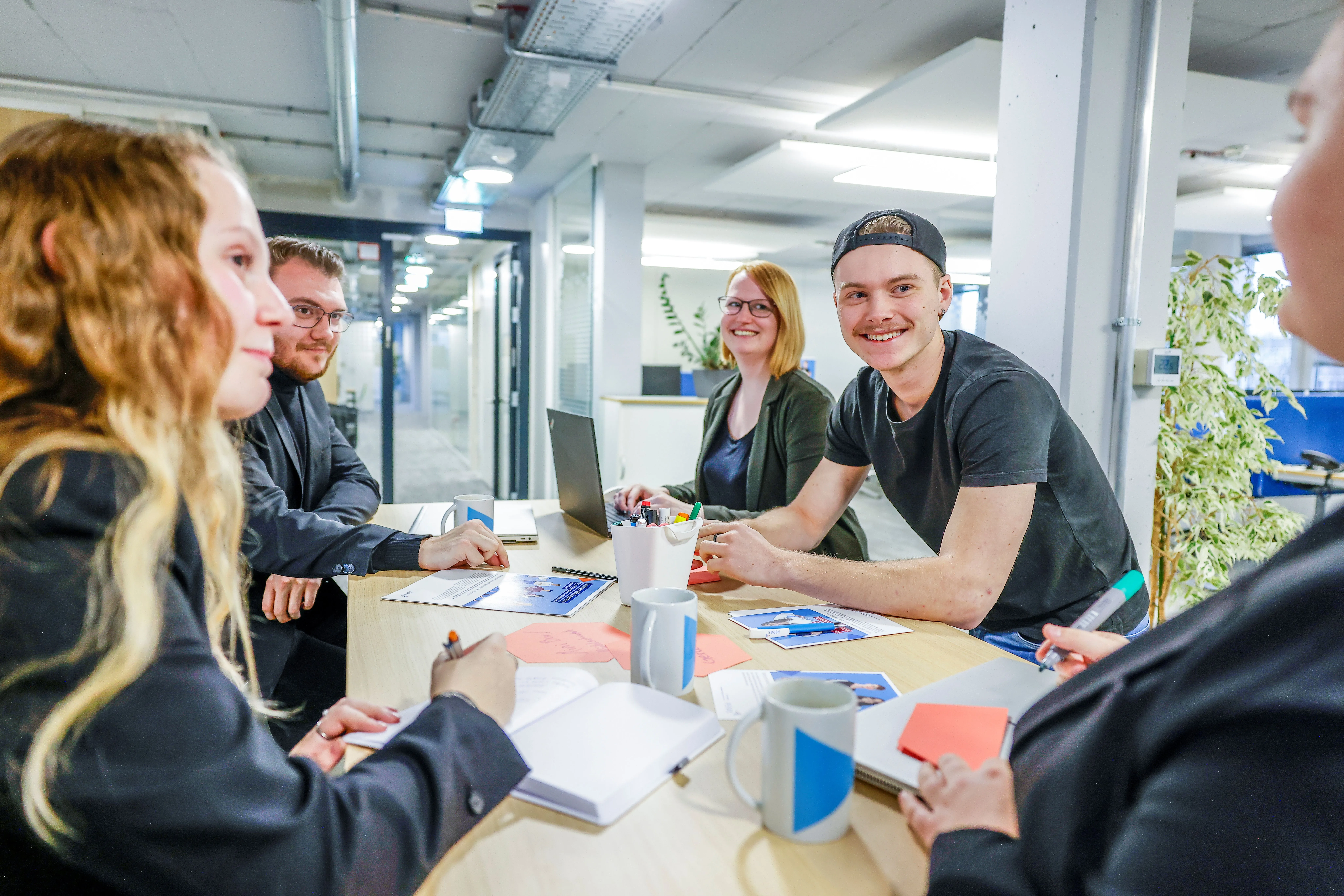 Drei Kolleginnen arbeiten gemeinsam an einem Whiteboard und tauschen sich über neue Ideen im HR-Bereich aus.
