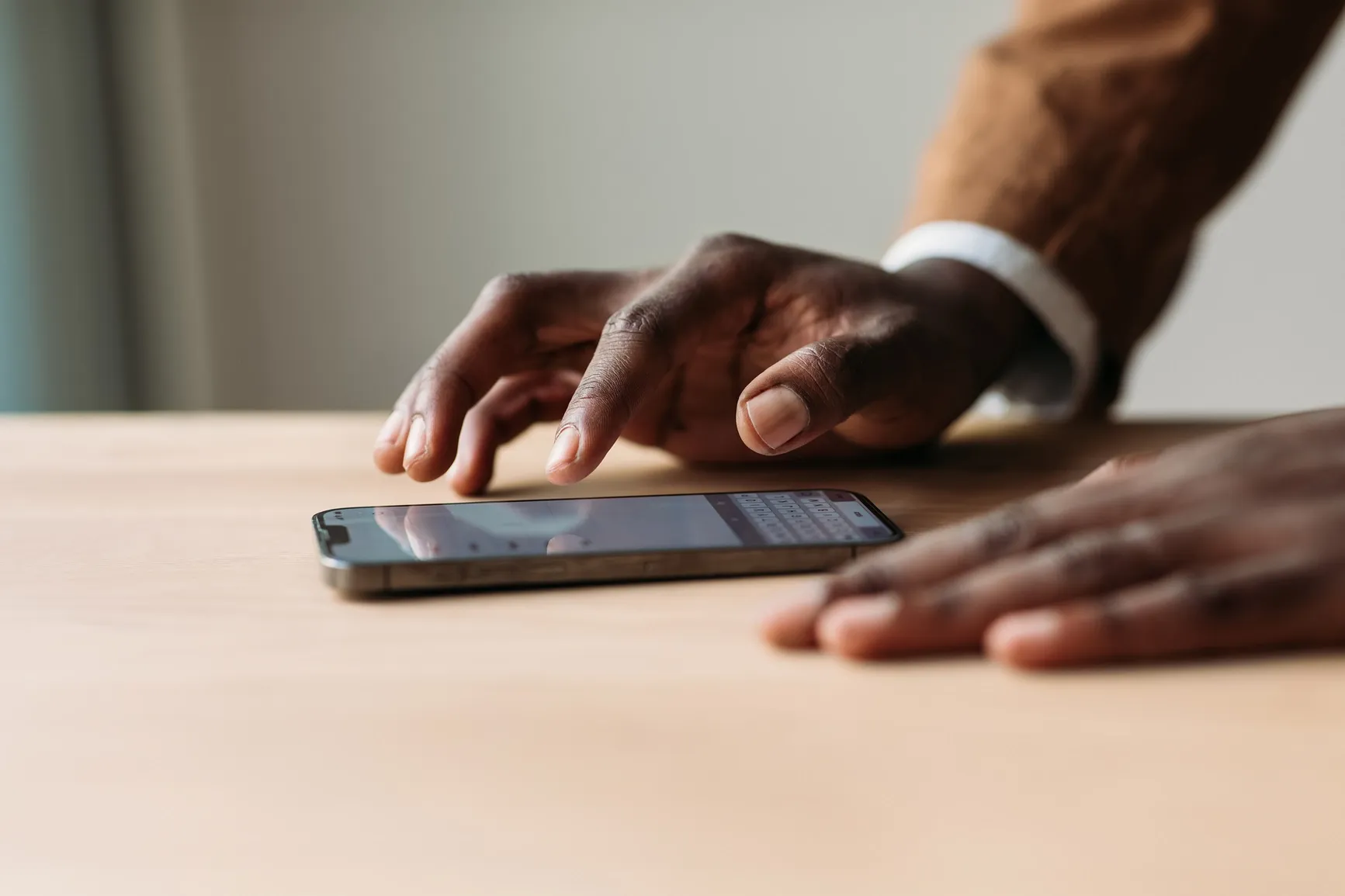Close-up of someone texting on a smartphone at a desk, showing a modern, tech-savvy work vibe at Ratepay.