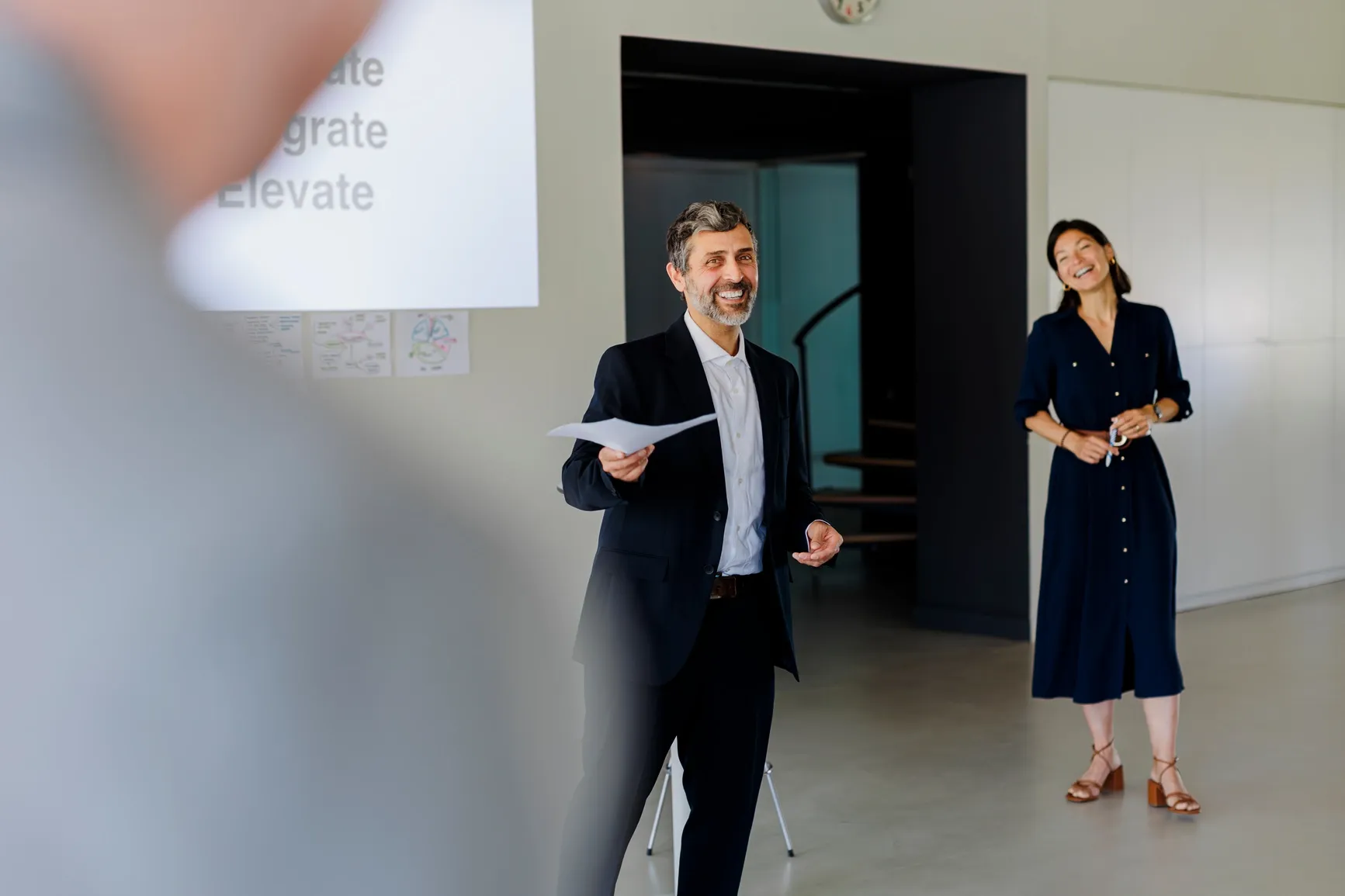 Two colleagues at ratepay GmbH sharing a laugh during a relaxed finance team presentation.