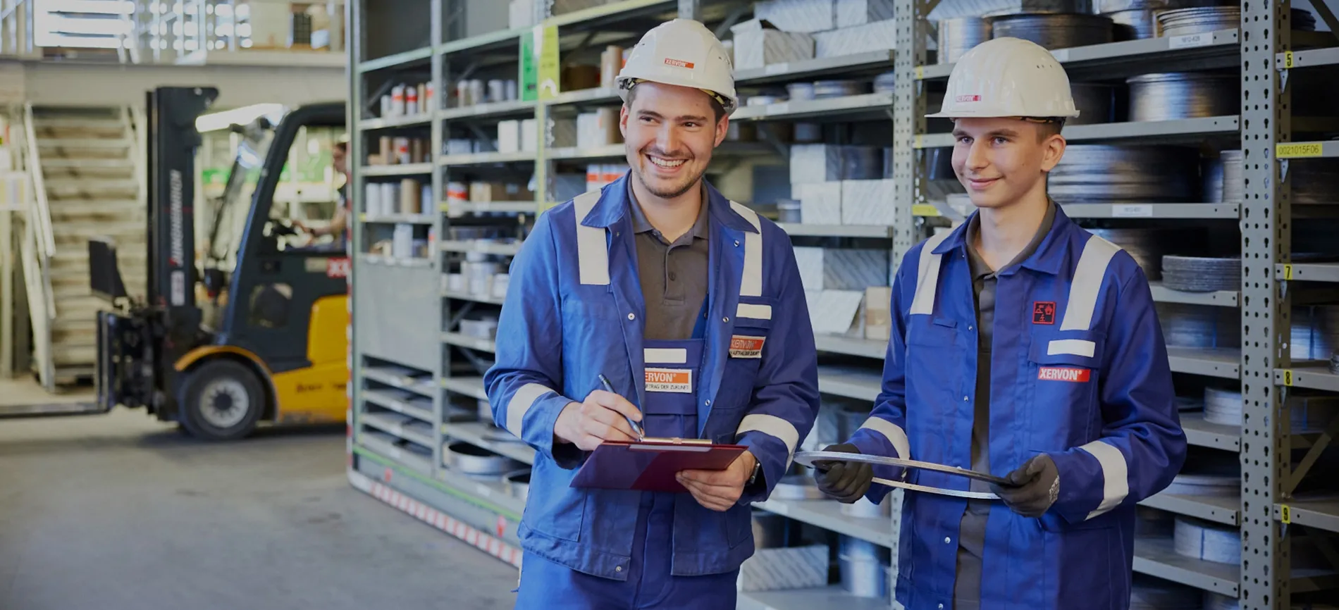 Mitarbeiter in Arbeitskleidung hält Bauteil in Werkhalle bei REMONDIS Assets & Services, Energie- und Versorgungsbranche.