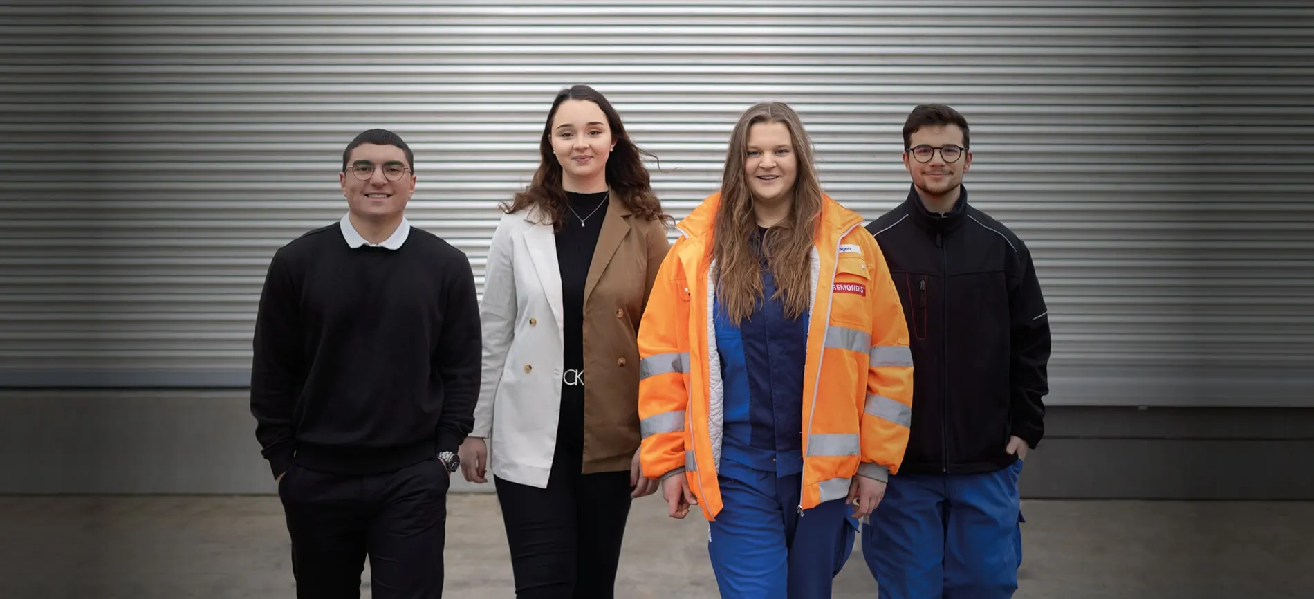 2 junge Männer & Frauen vor grauer Wand