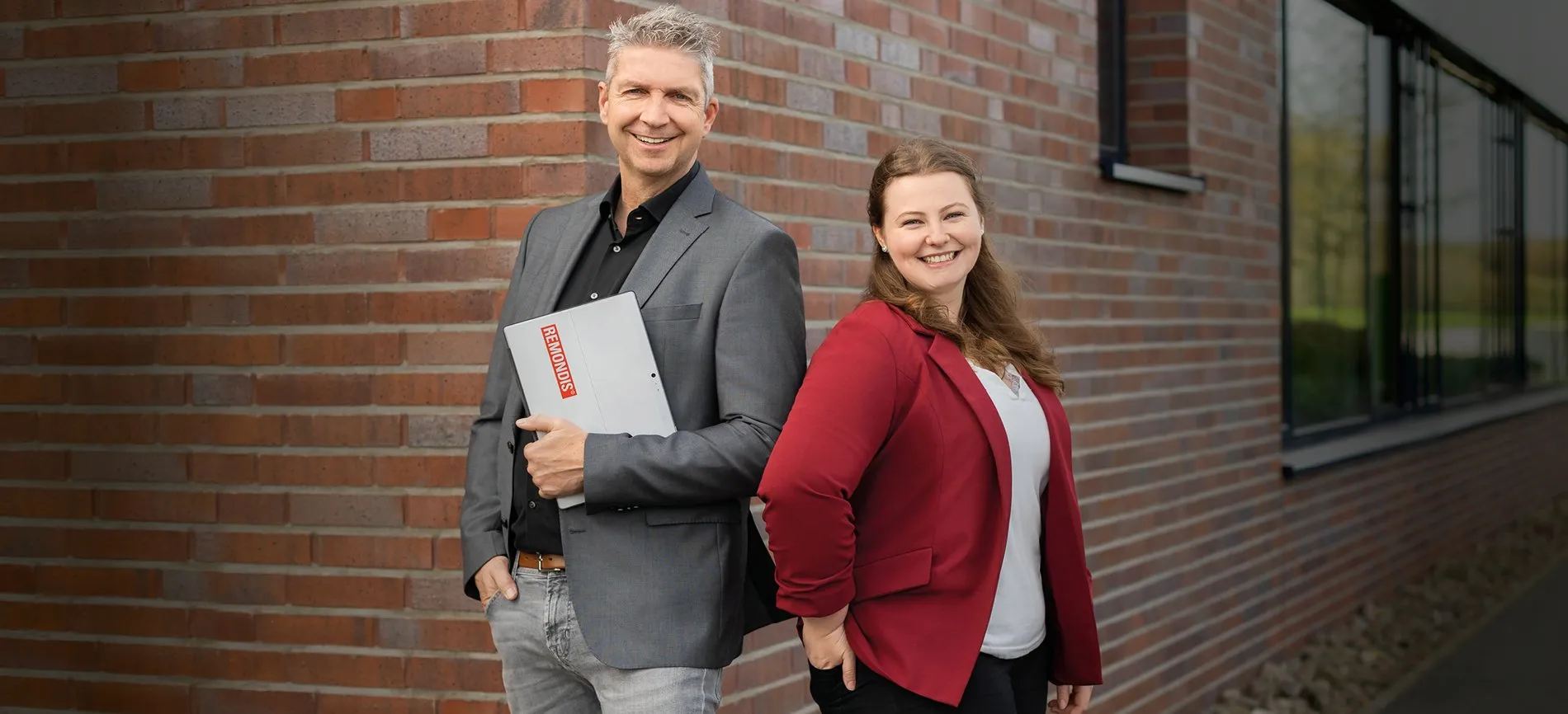 Mann und Frau lachend vor Wand
