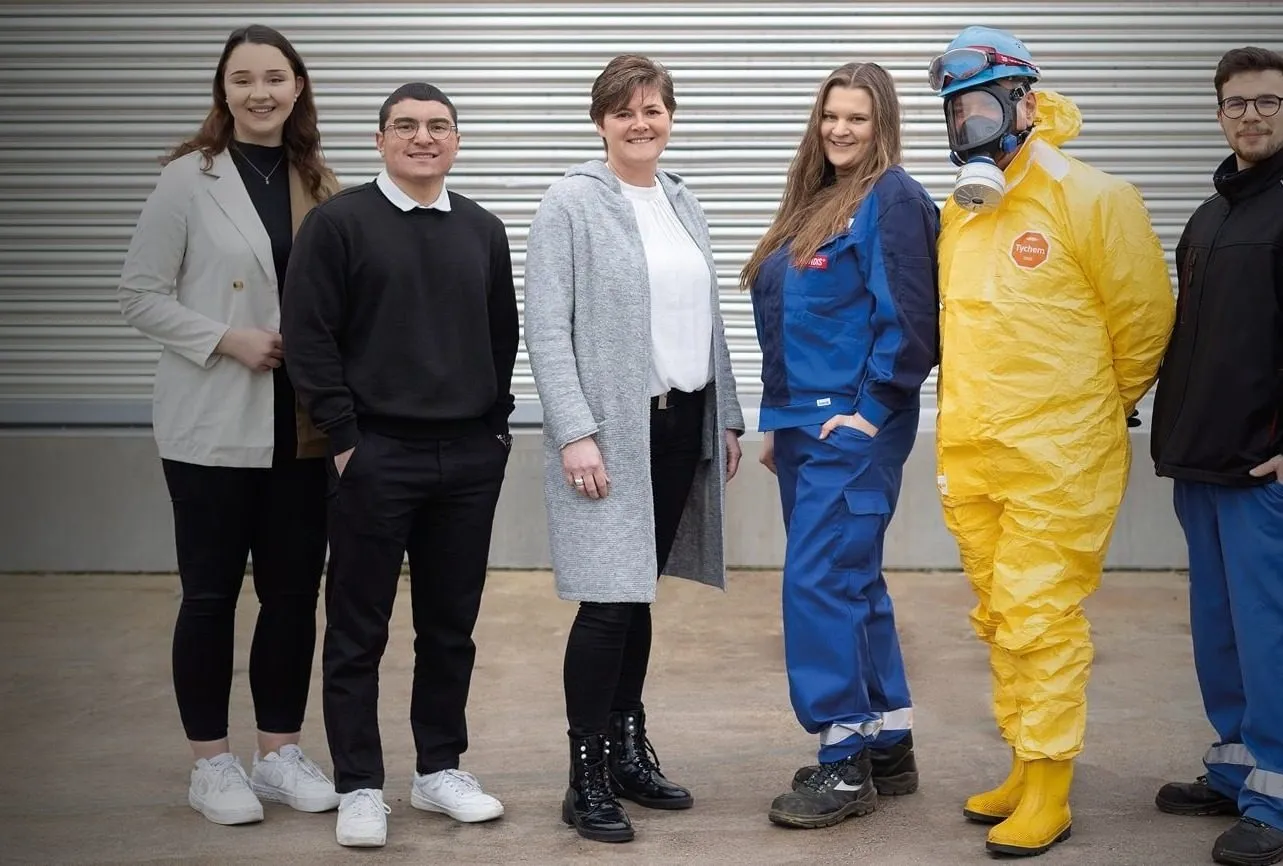 Mitarbeiter vor grauer Wand