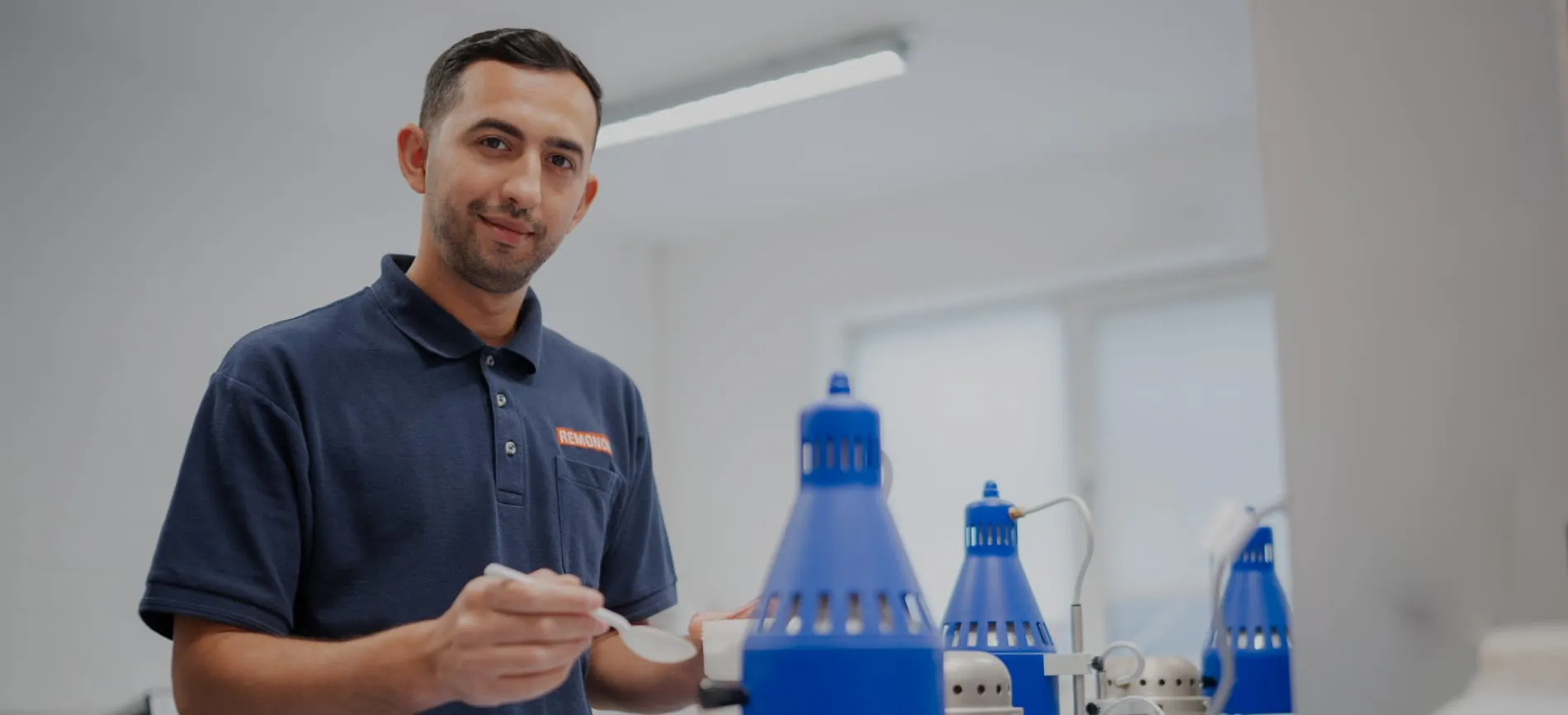 Ein Mitarbeiter im REMONDIS-Poloshirt arbeitet konzentriert im Labor und bereitet eine Probe vor.