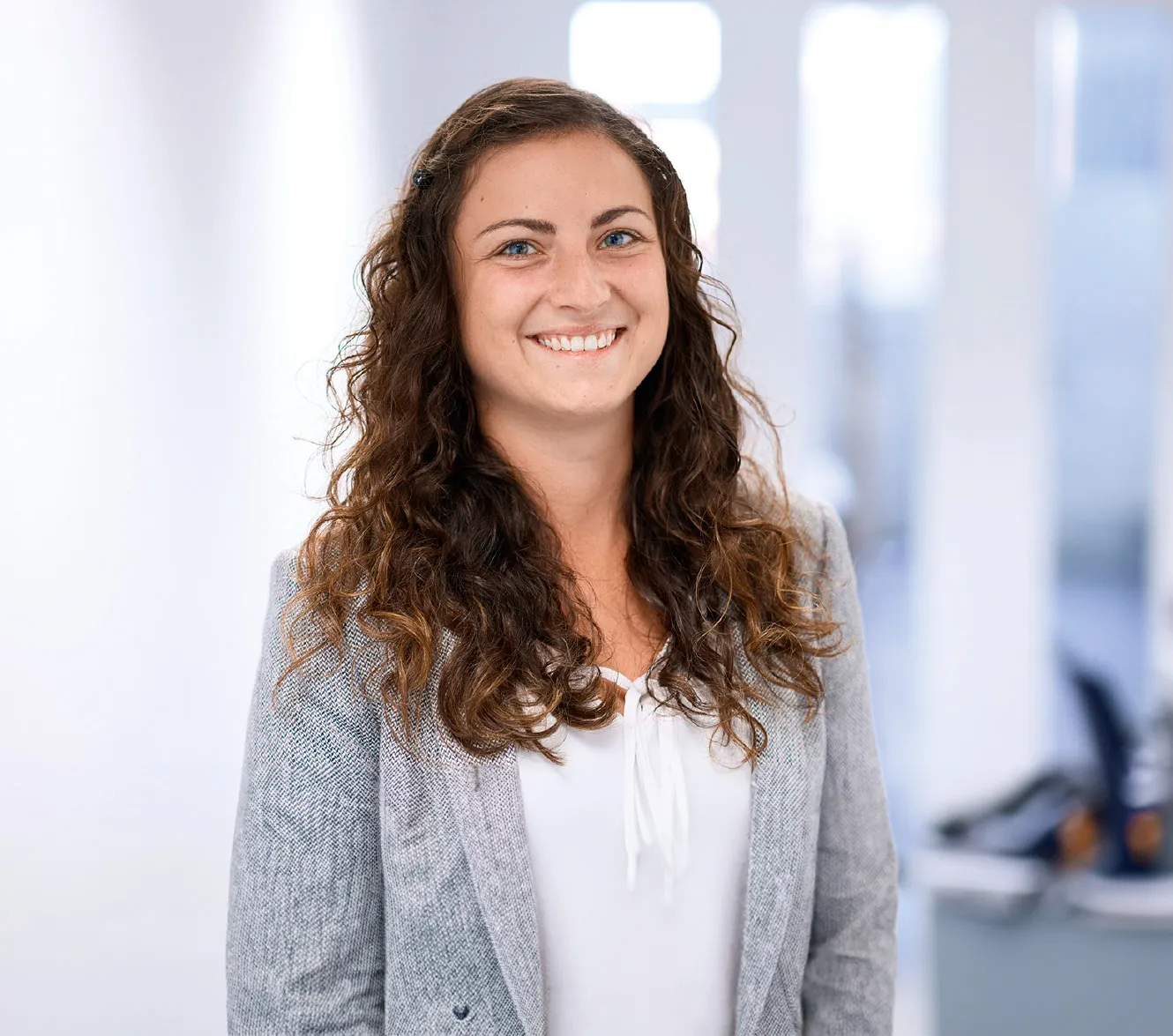 Eine lächelnde Frau in einem Büro, die für Rittal GmbH & Co. KG im IT-Bereich arbeitet.