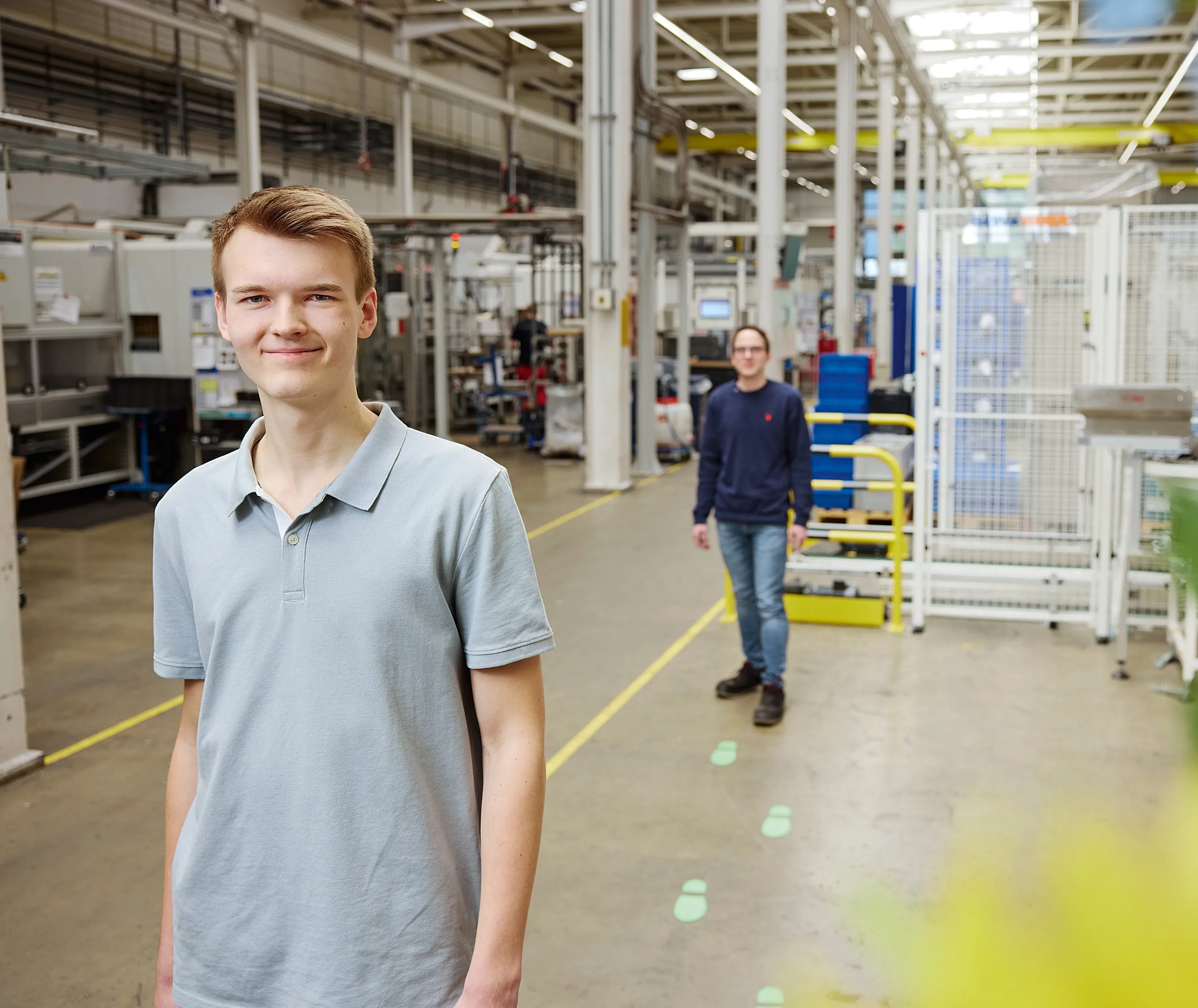 Two employees in a bright, spacious Rittal GmbH & Co. KG facility, showcasing a tech-focused work environment.