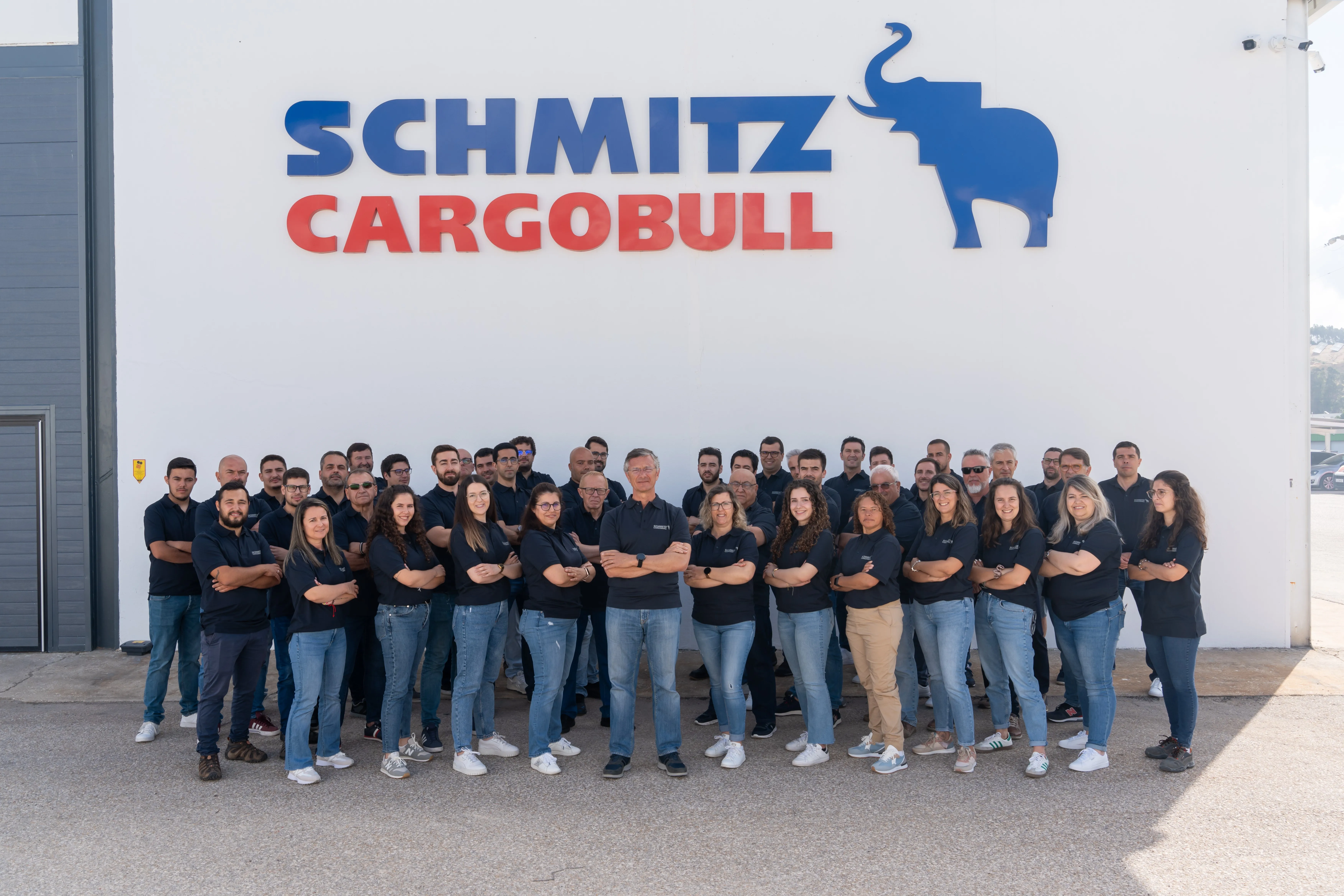Schmitz Cargobull AG office with company flags and parked trailer truck, showcasing the automotive industry vibe.