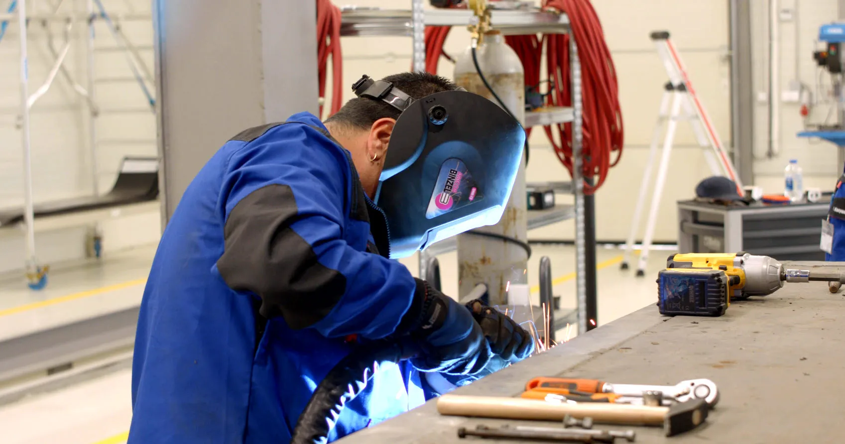 Welding magic in action at Schmitz Cargobull AG, with a technician in a blue jacket focused on precision work.