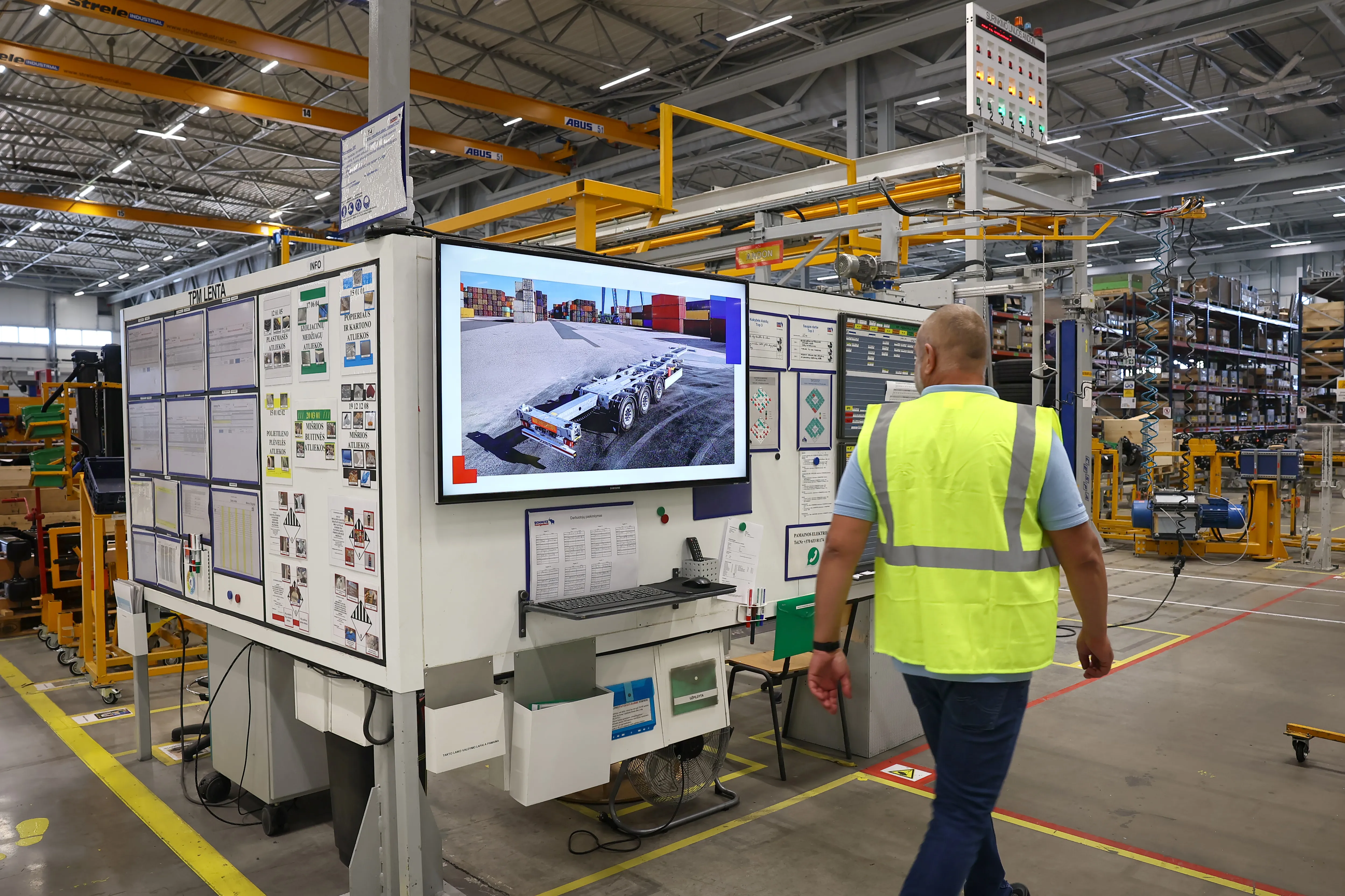 Two young engineers at Schmitz Cargobull AG discussing a complex automotive system with a tablet.