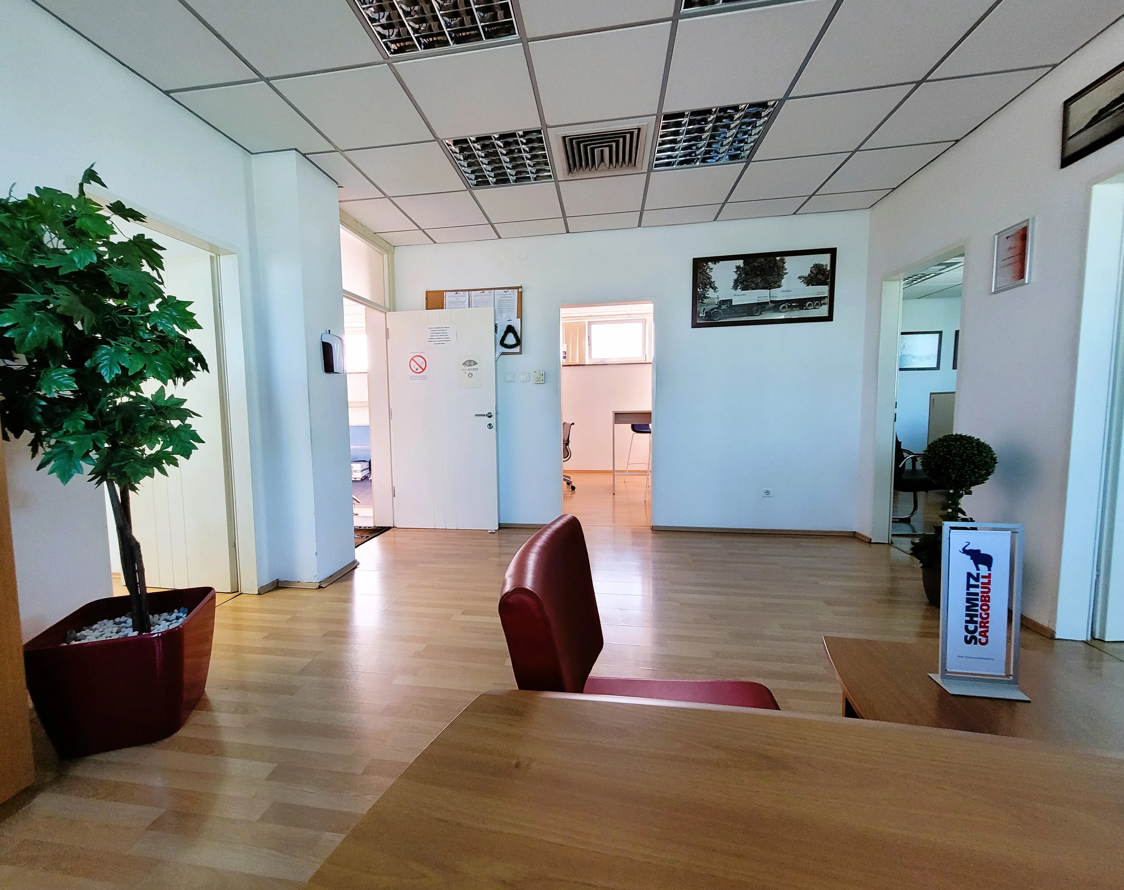 A Schmitz Cargobull truck parked outdoors, with trailers and a clear blue sky in the background.
