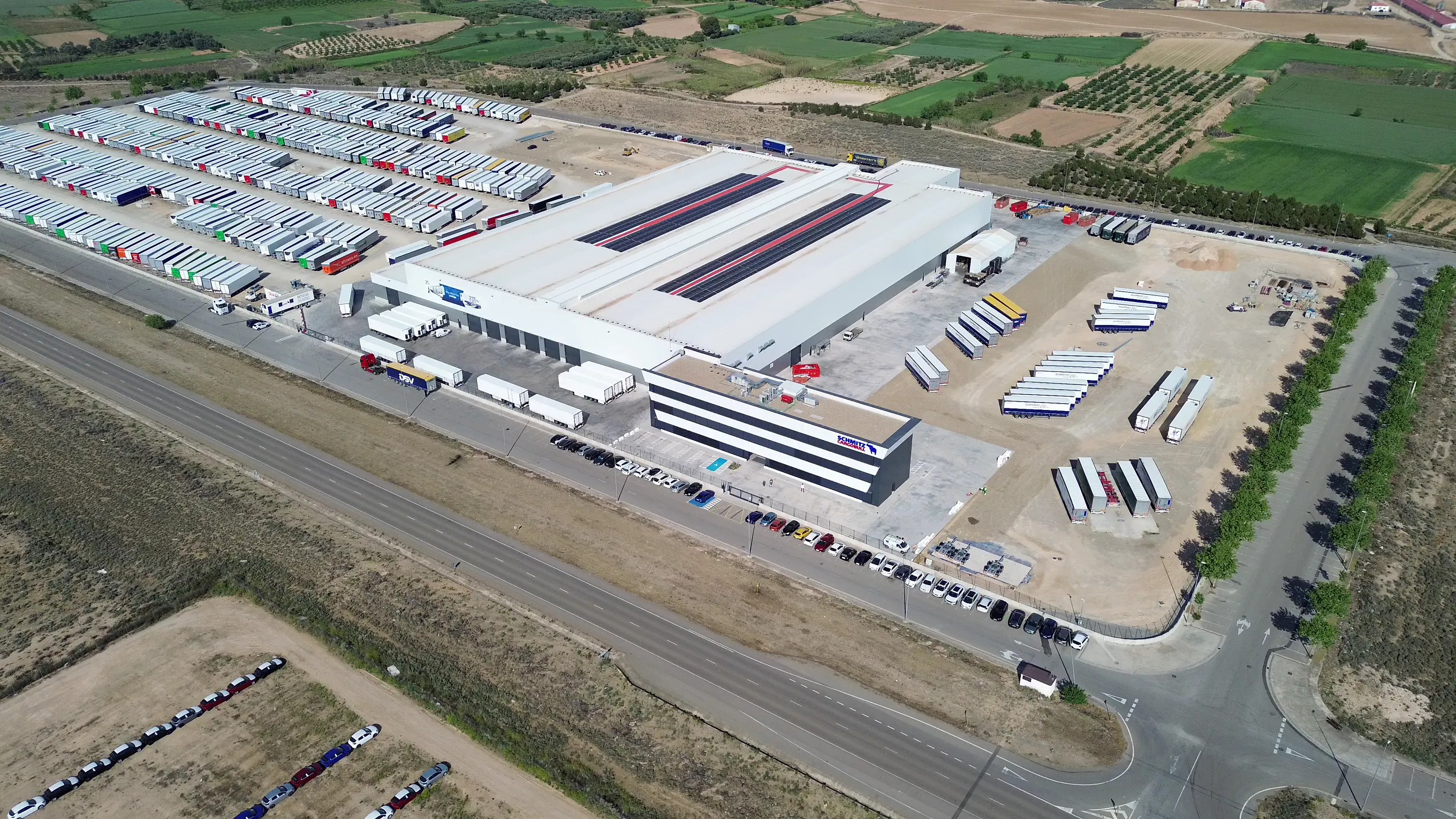 Aerial view of Schmitz Cargobull AG's expansive automotive facility, showcasing rows of trailers and a modern warehouse.