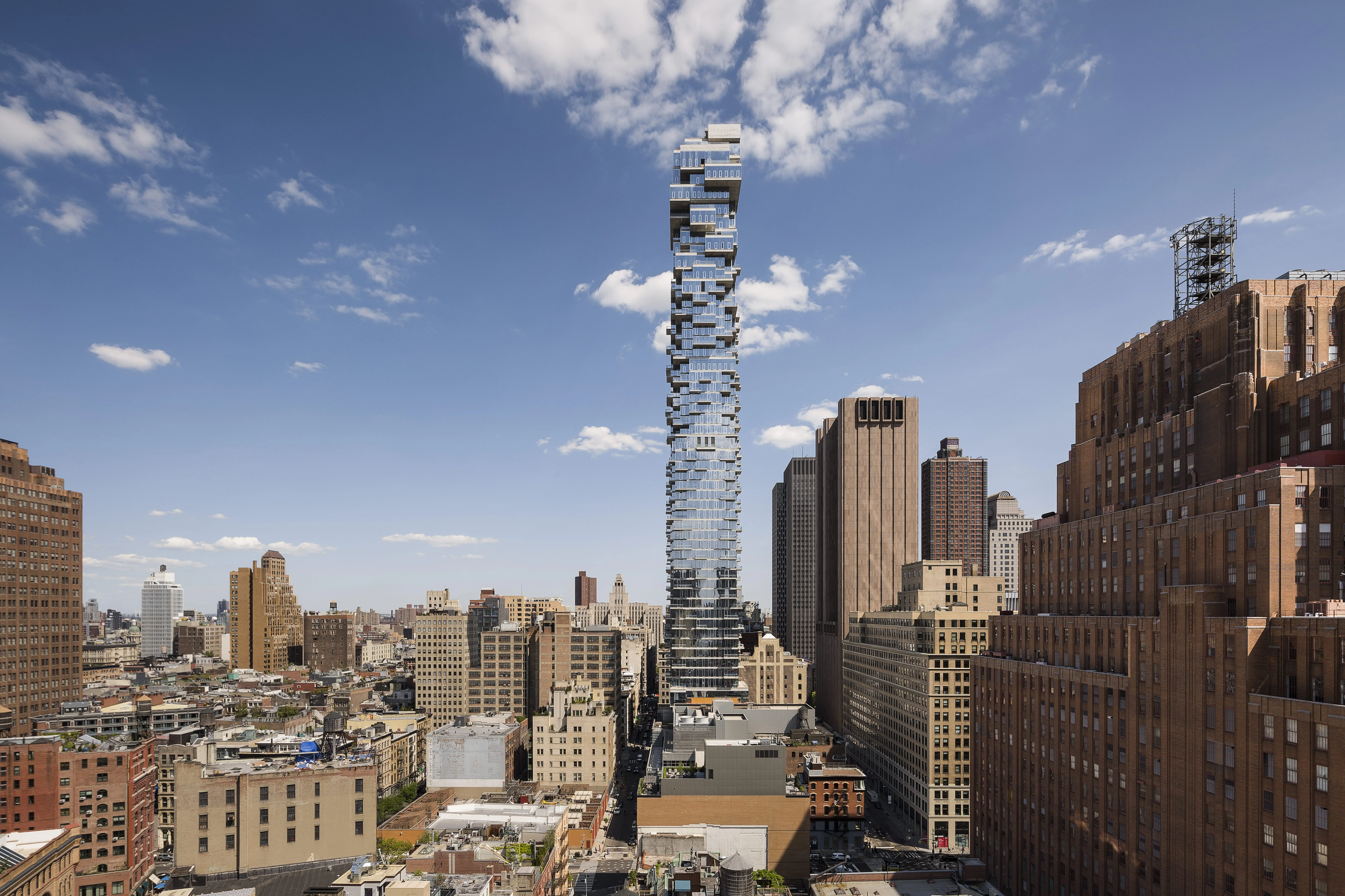 Ein modernes Hochhaus mit innovativer Architektur ragt über die Skyline einer Stadt. Perfekt für eine Karriere im Bauwesen bei Schüco.