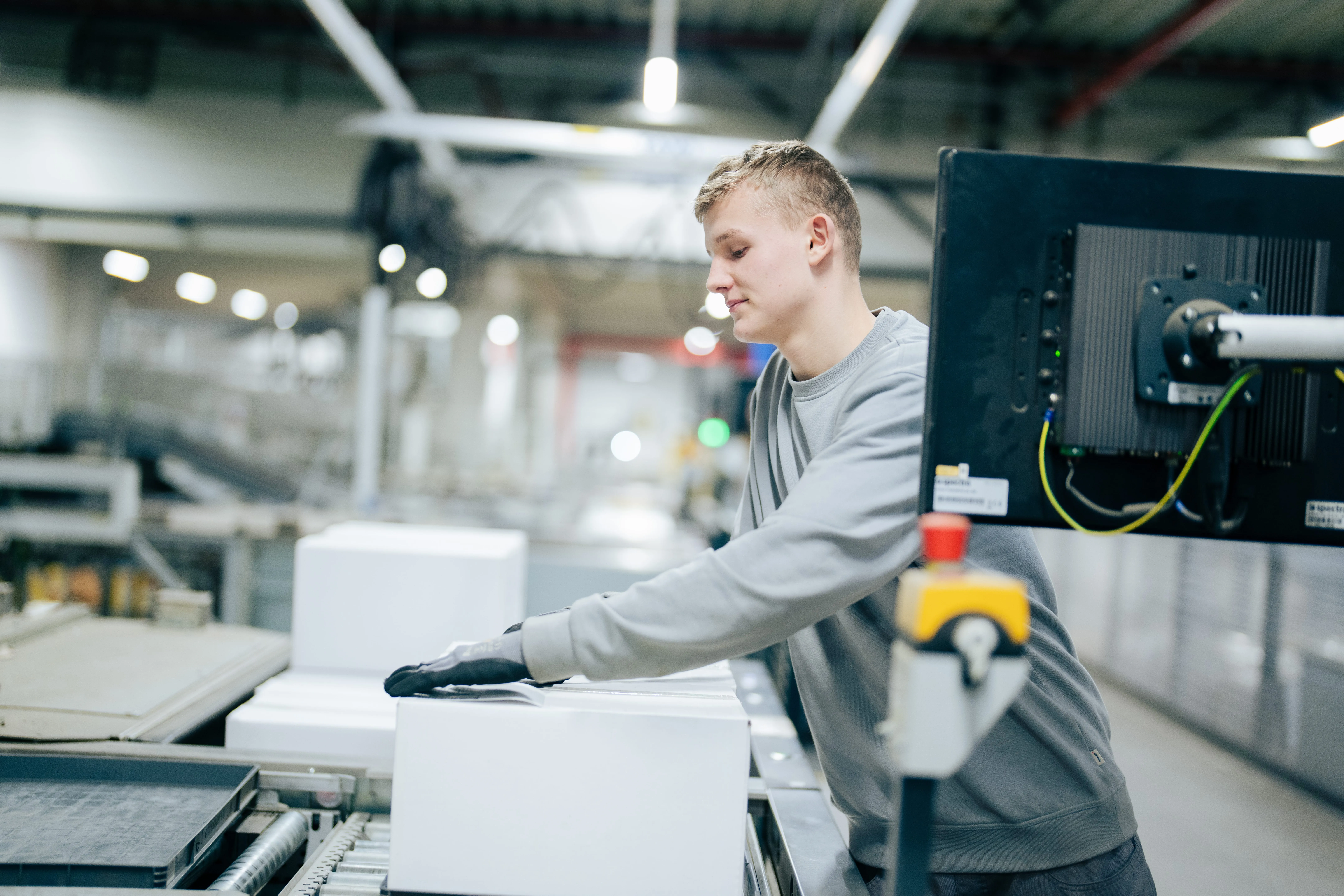 Zwei junge Menschen in einem modernen Büro, die gemeinsam auf ein Tablet schauen. Ideal für eine Karriere bei Schüco im Bauwesen.