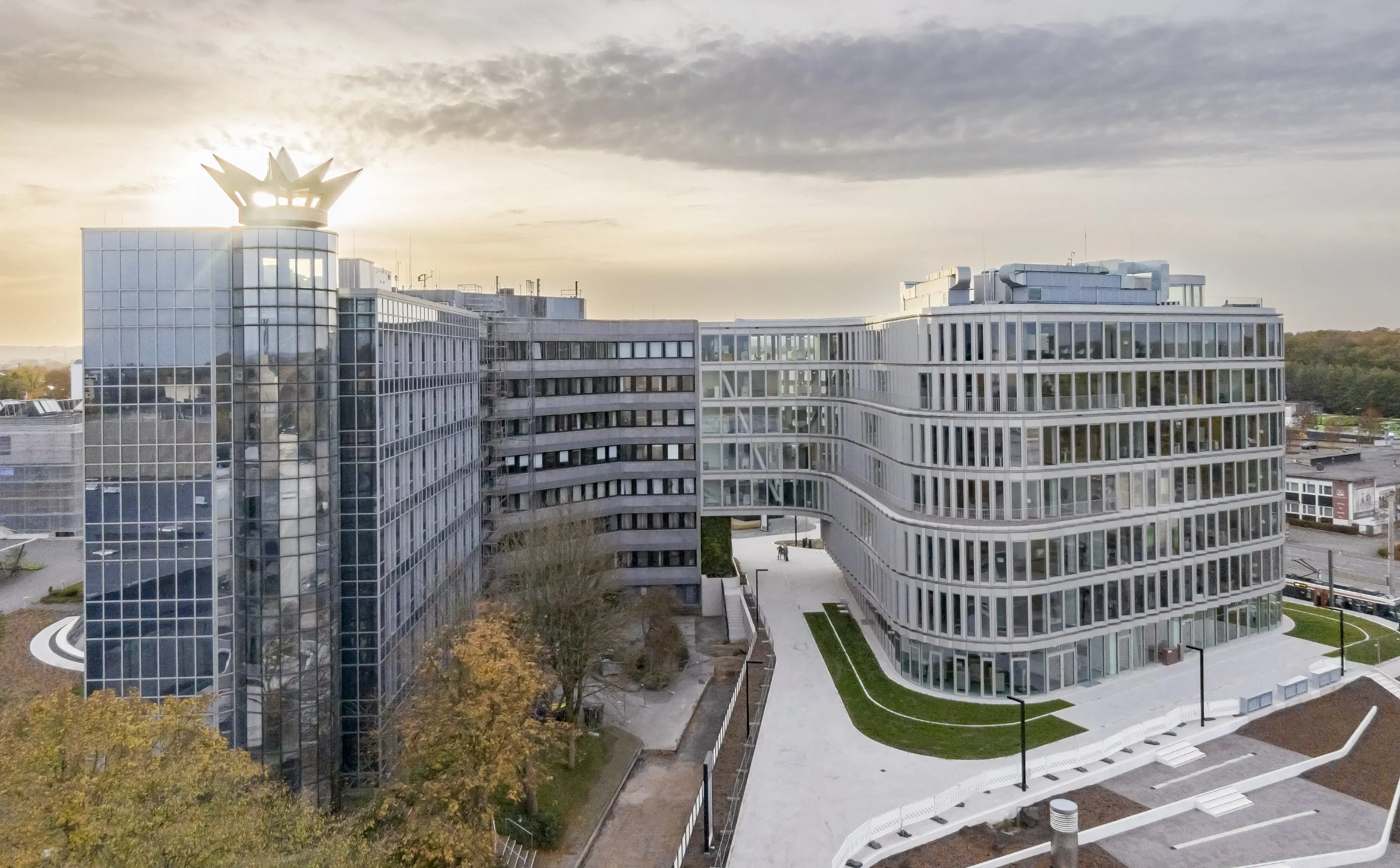 Luftaufnahme von modernen Bürogebäuden von Schüco International KG bei Sonnenuntergang, umgeben von Bäumen und Straßen.