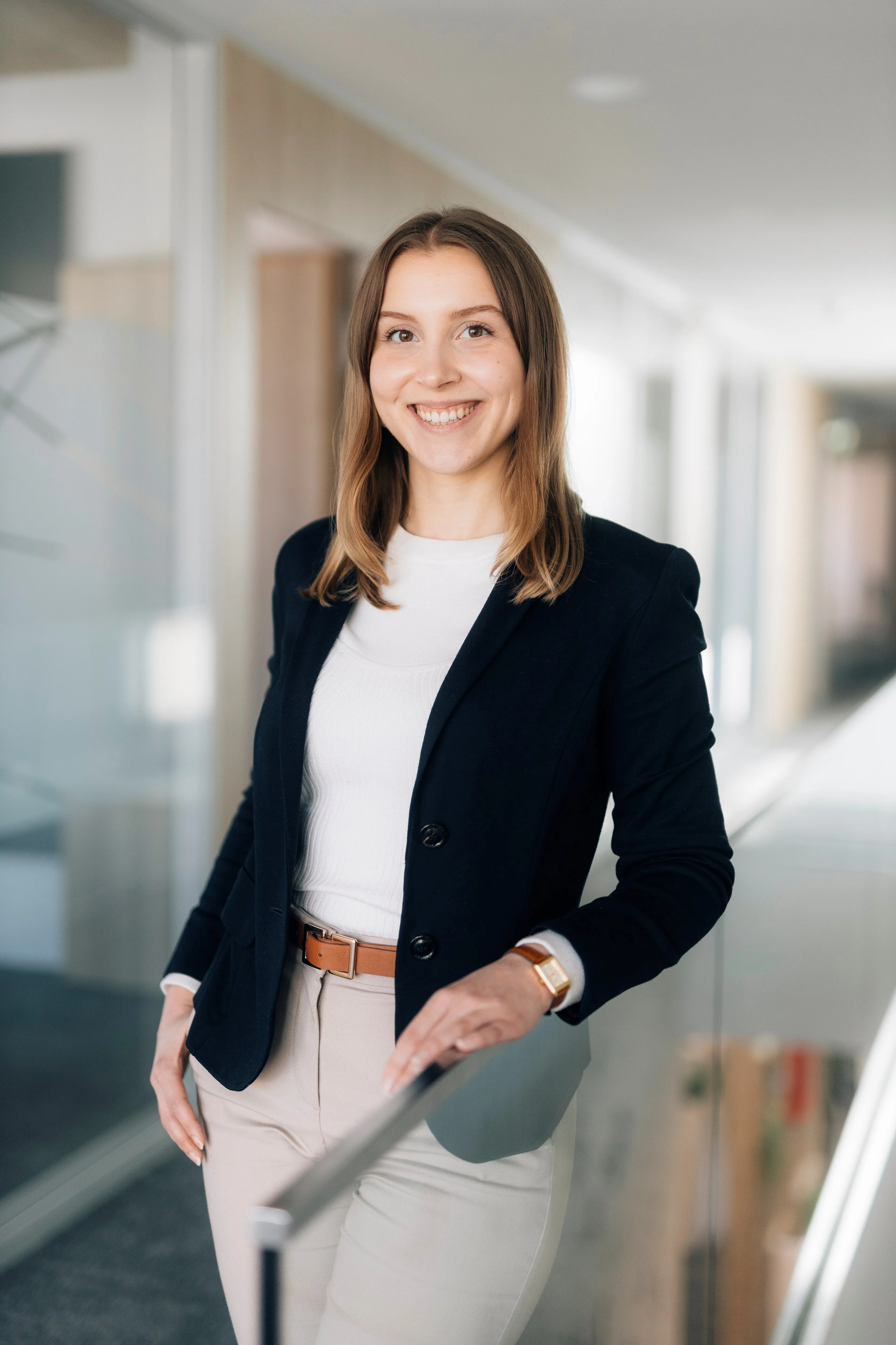 Junge Frau im Business-Outfit lächelt freundlich im modernen Büro der Sparkasse Bielefeld.