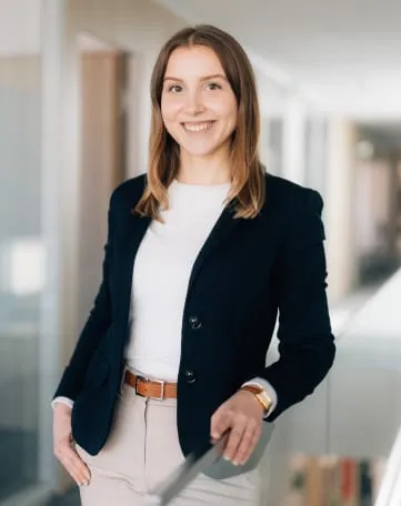 Junge Frau im Business-Outfit lächelt freundlich im modernen Büro der Sparkasse Bielefeld – Deine Karriere beginnt hier.