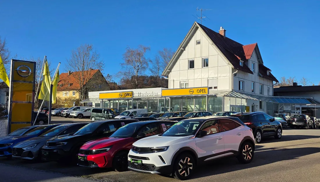 Mehrere Opel-Neuwagen stehen vor einem Autohaus, bereit für Deinen Karrierestart in der Automobilbranche.