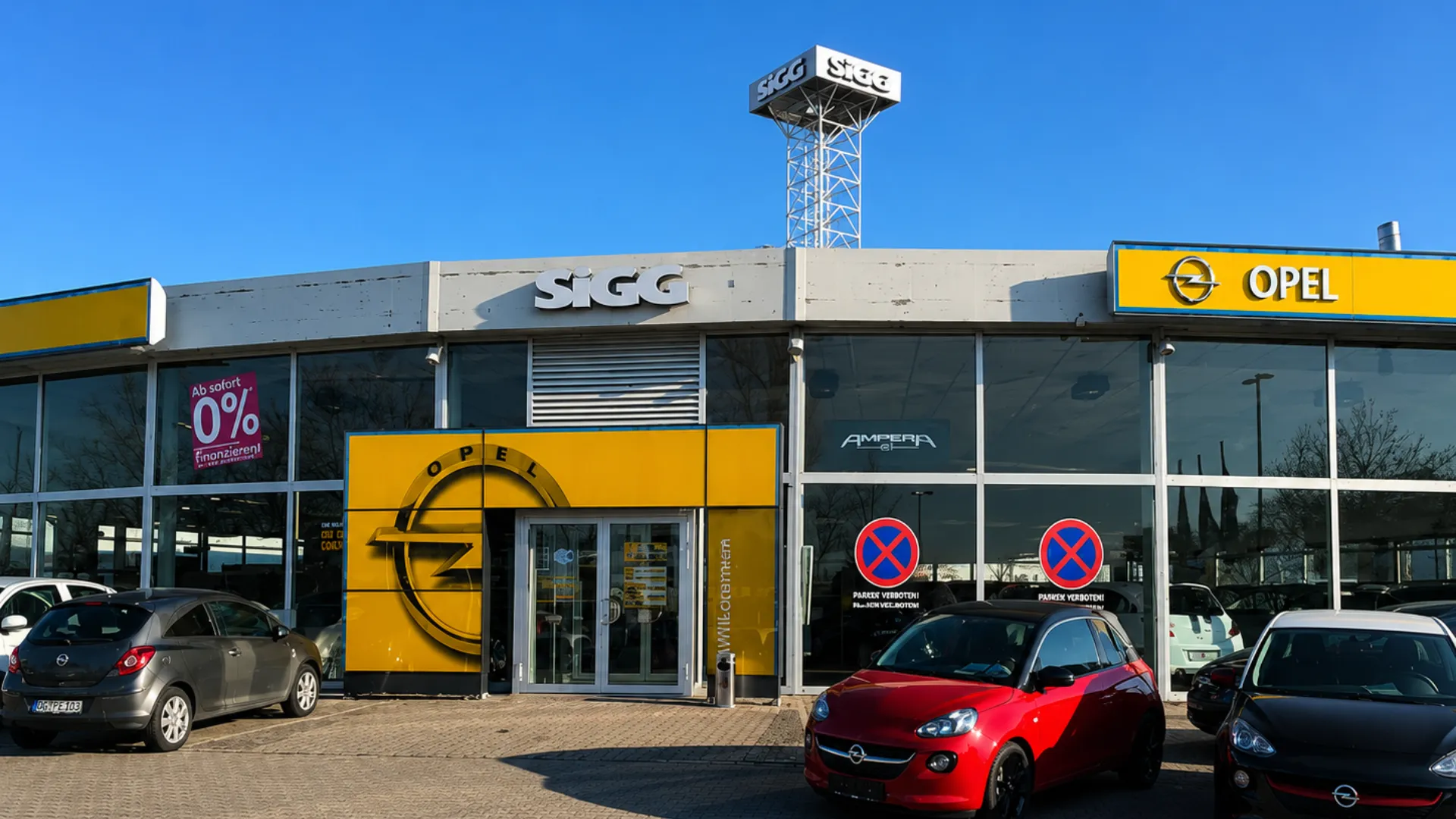 Außenansicht eines Opel Autohauses mit geparkten Autos und großem Opel-Logo, um Dich für eine Karriere bei Stellantis zu inspirieren.