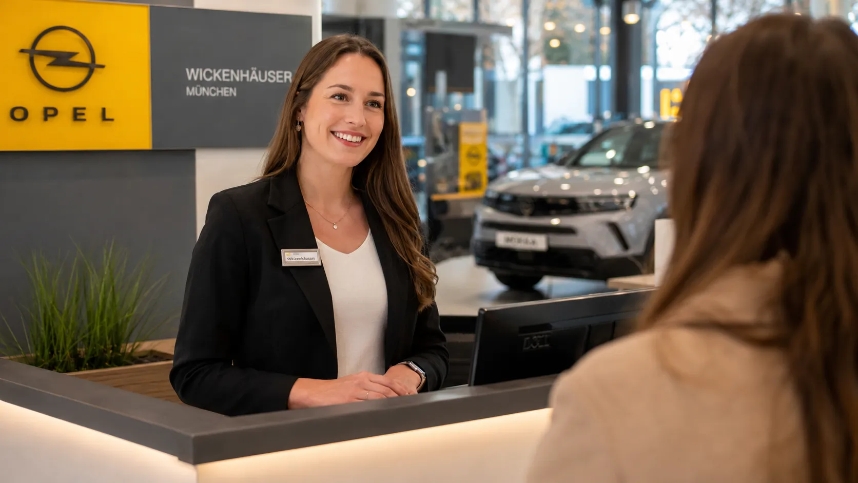 Freundliche Mitarbeiterin begrüßt Dich an der Rezeption eines Opel Autohauses bei Stellantis in München.