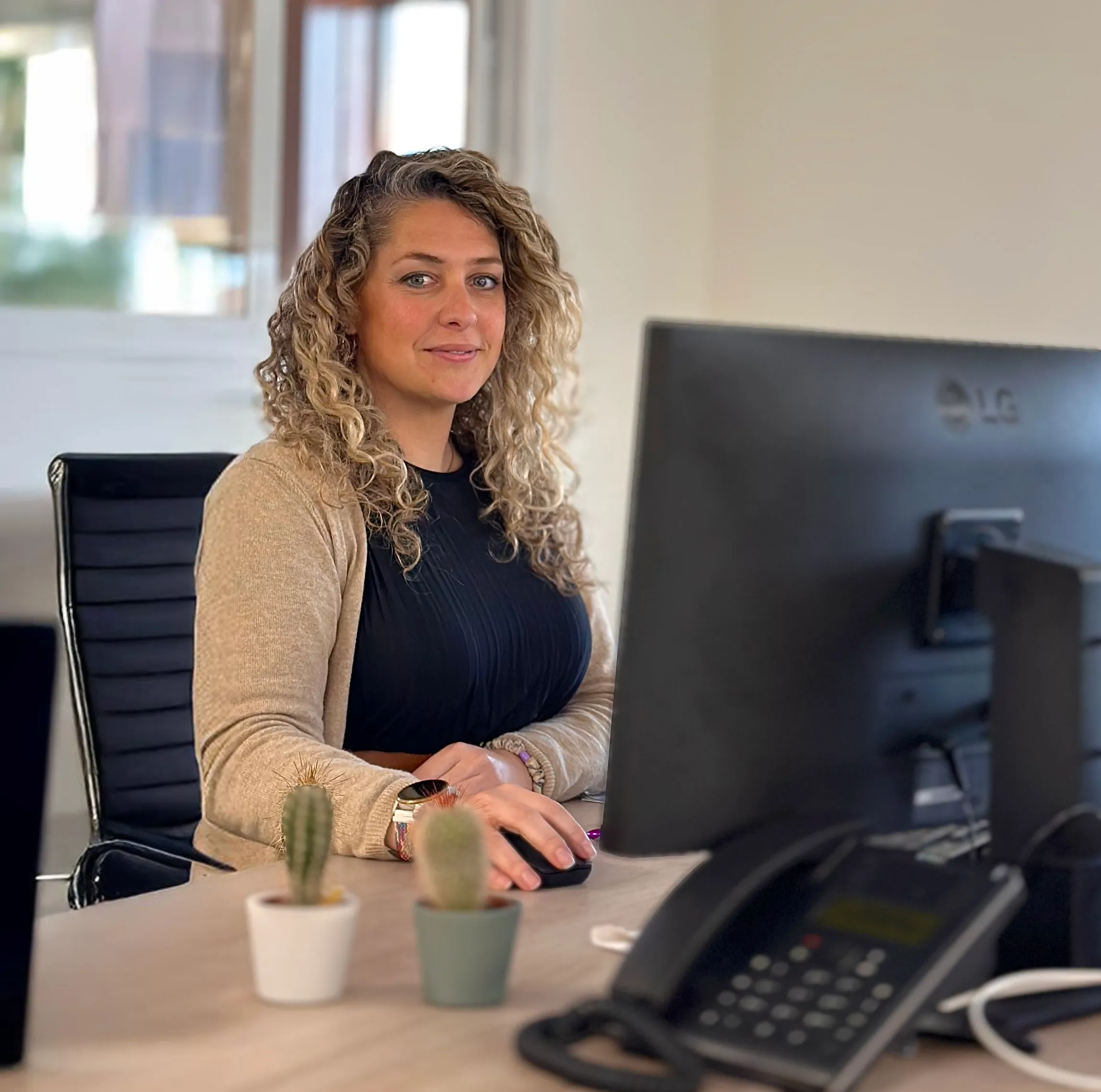 Eine Frau mit Headset lächelt am Schreibtisch mit Tastatur und Maus bei Storch-Ciret Business Services GmbH.